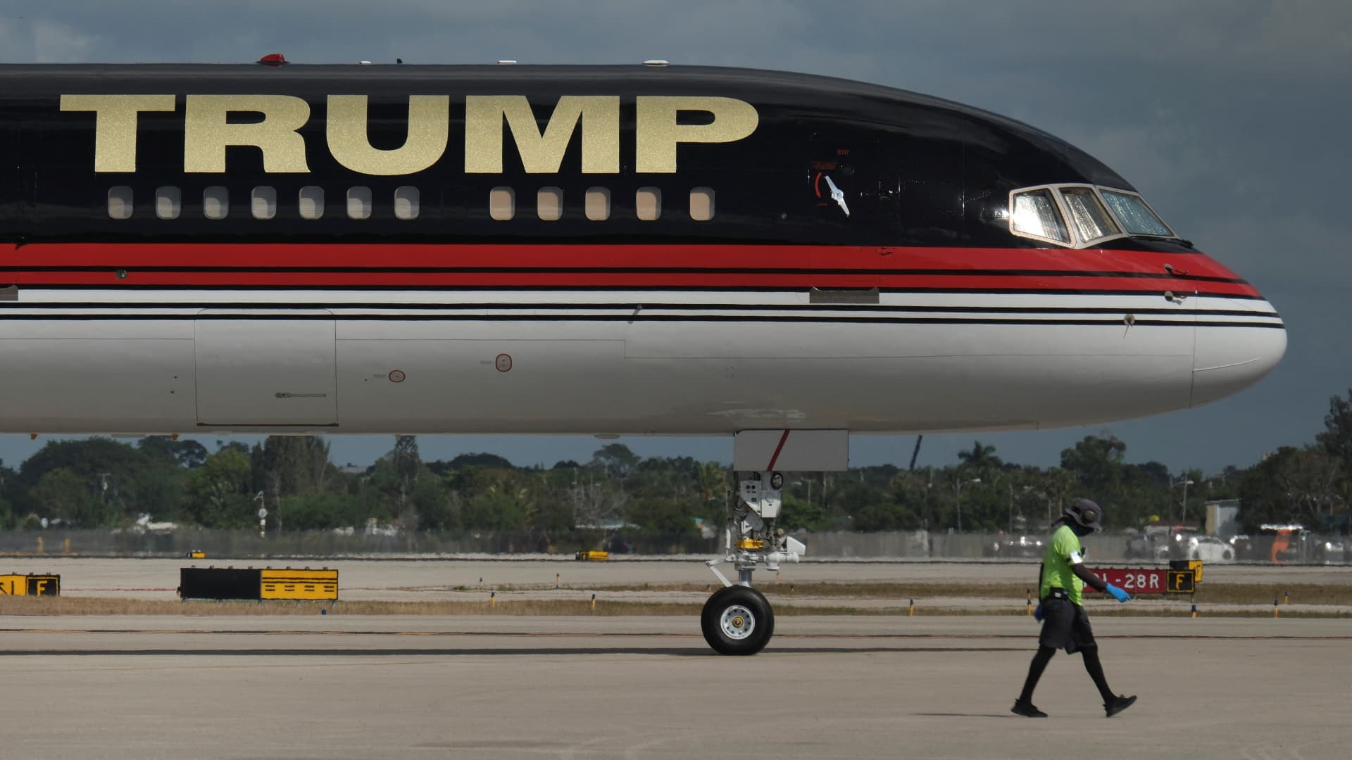 A ground crew member walks past the plane of former U.S. President Donald Trump parked at the Palm Beach International Airport, in West Palm Beach, Florida, U.S. March 27, 2023.