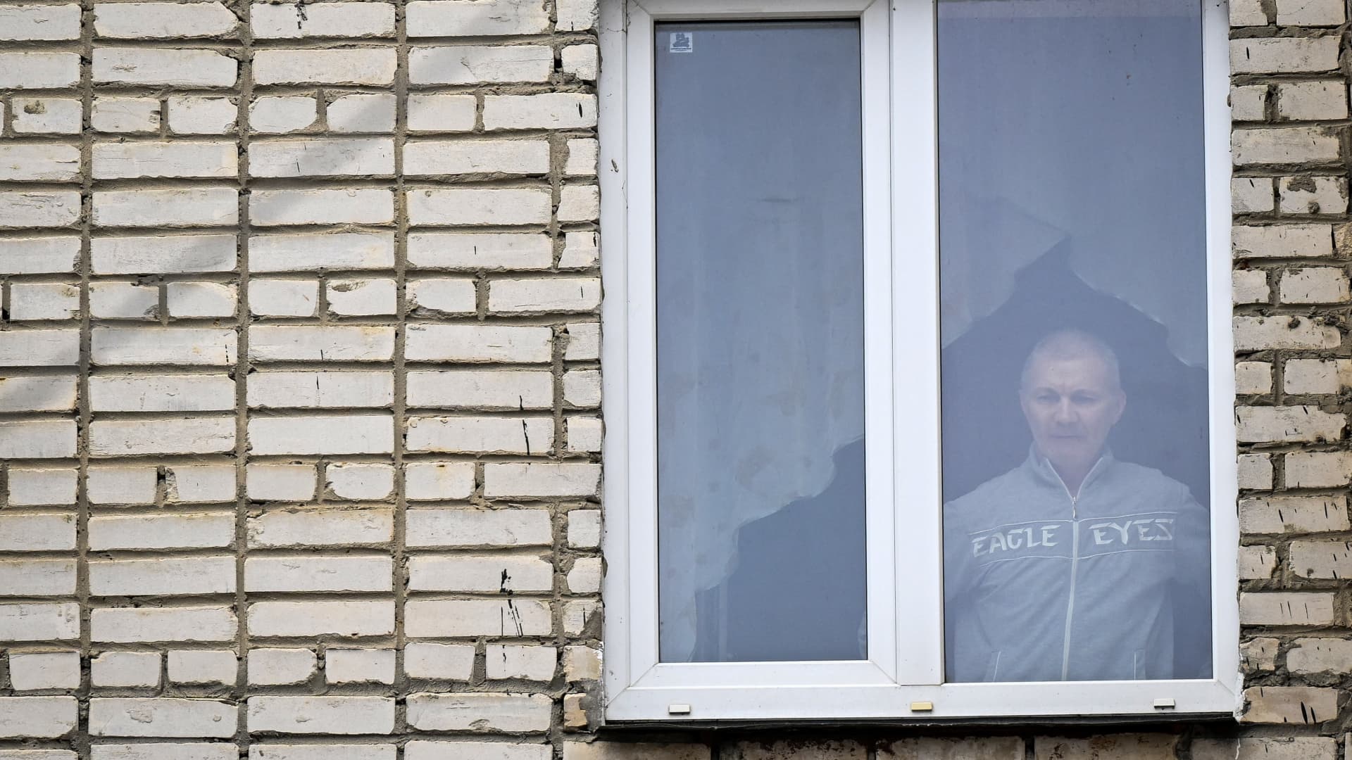 Alexei Moskalyov, 54, a single parent of Maria Moskalyova, the 13-year-old girl who drew a picture critical of Moscow's military campaign in Ukraine at school in April last year, looks out through the window of his flat after he was placed under house for repeating Ukraine posts discrediting the Russian army, in the town of Yefremov in the Tula region on March 23, 2023.