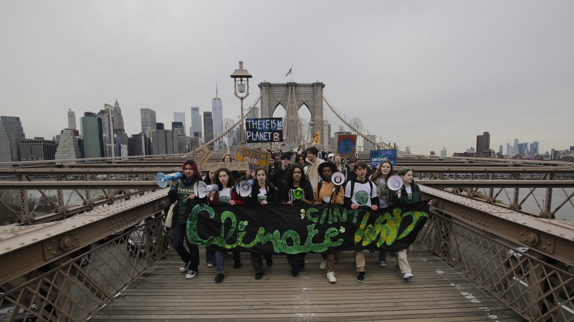 People walk through the Brooklyn Bridge during a strike for climate on March 03, 2023 in New York City. Protesters demand New York State support found and pass the Climate Jobs, and Justice Package.