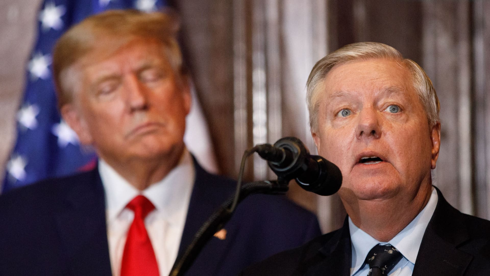 Former US President Donald Trump looks on as US Senator Lindsey Graham (R-SC) addresses the crowd during a 2024 election campaign event in Columbia, South Carolina, on January 28, 2023.