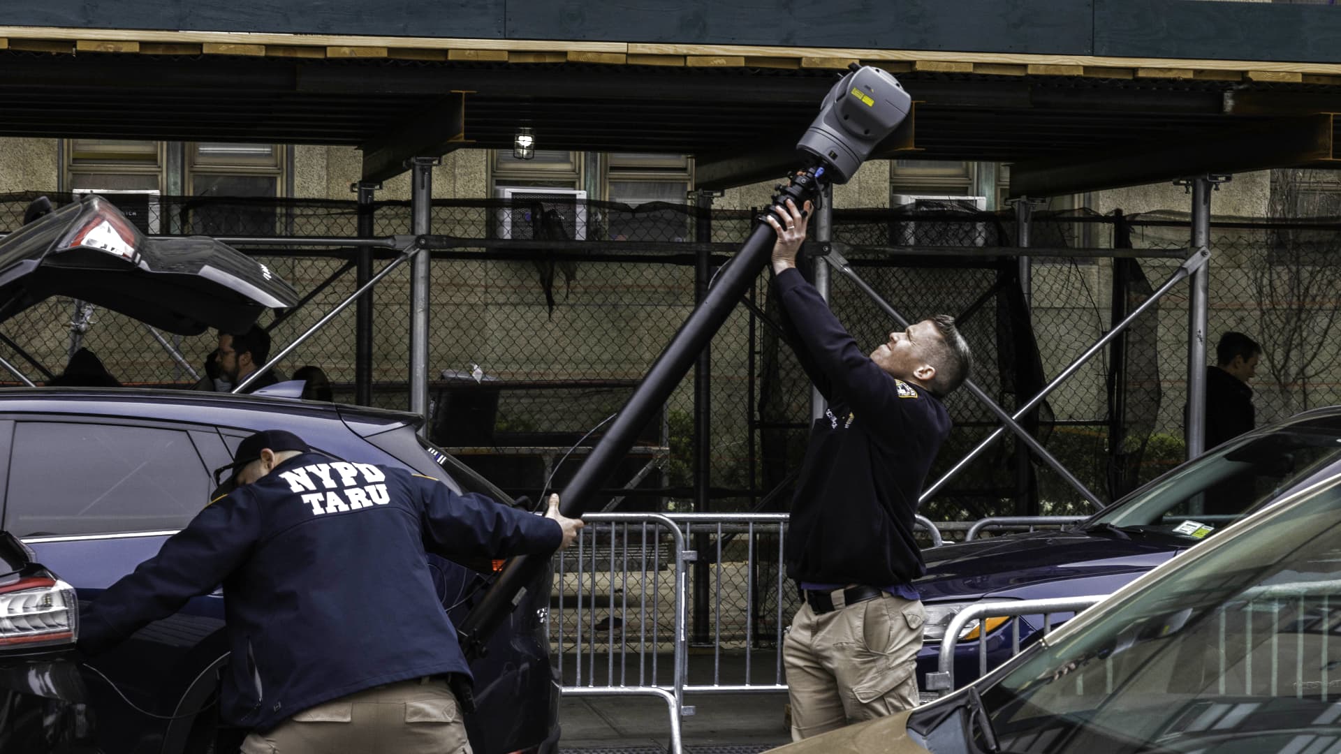 Members of the New York Police Department (NYPD) Technical Assistance Response Unit (TARU) install surveillance equipment outside the criminal courthouse after the indictment of former US President Donald Trump in New York, US, on Friday, March 31, 2023.