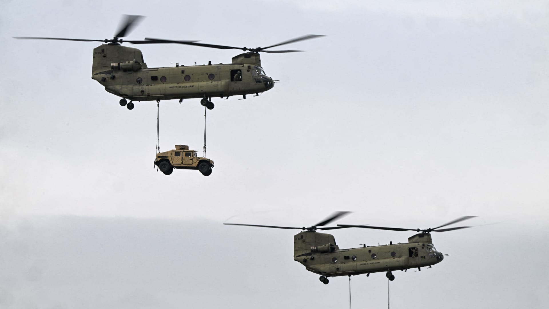 Boeing CH-47F Chinook tandem rotor helicopters (Vertol) transport military vehicles during a demonstration as part of the rotation of US troops of the US Army 101 Airborne division at Mihail Kogalniceanu Air Base (RoAF 57th Air Base) near Constanta, Romania on March 31, 2023. 