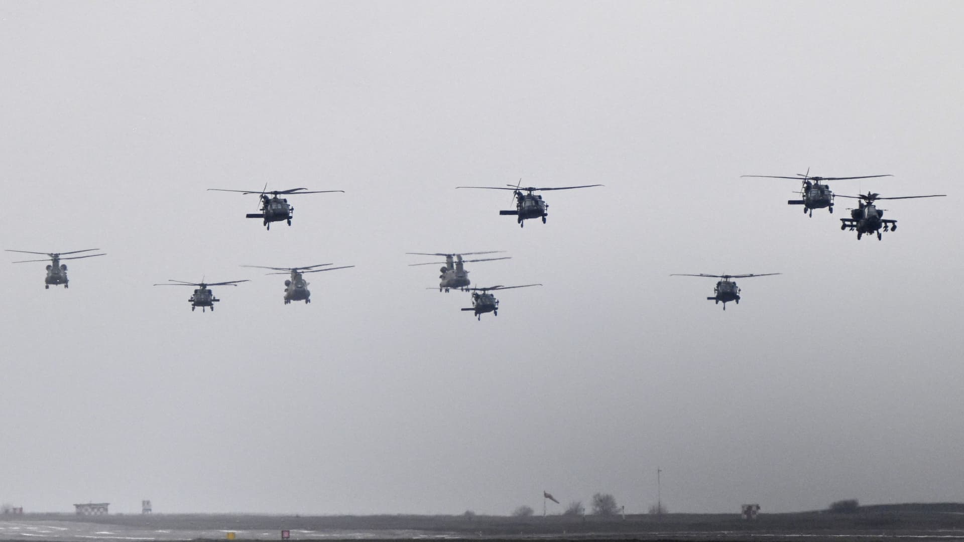 Different types of helicopters, among them Chinook, Black Hawk and Apache, fly during the final display formation as part of the rotation of US troops of the US Army 101 Airborne division at Mihail Kogalniceanu Air Base (RoAF 57th Air Base) near Constanta, Romania on March 31, 2023. 