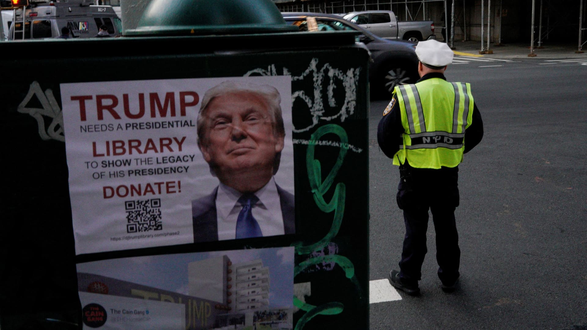 A law enforcement officer stands guard near a poster depicting former U.S. President Donald Trump outside Manhattan Criminal Courthouse, after Trump's indictment by a Manhattan grand jury following a probe into hush money paid to porn star Stormy Daniels, in New York City, U.S., April 4, 2023. 
