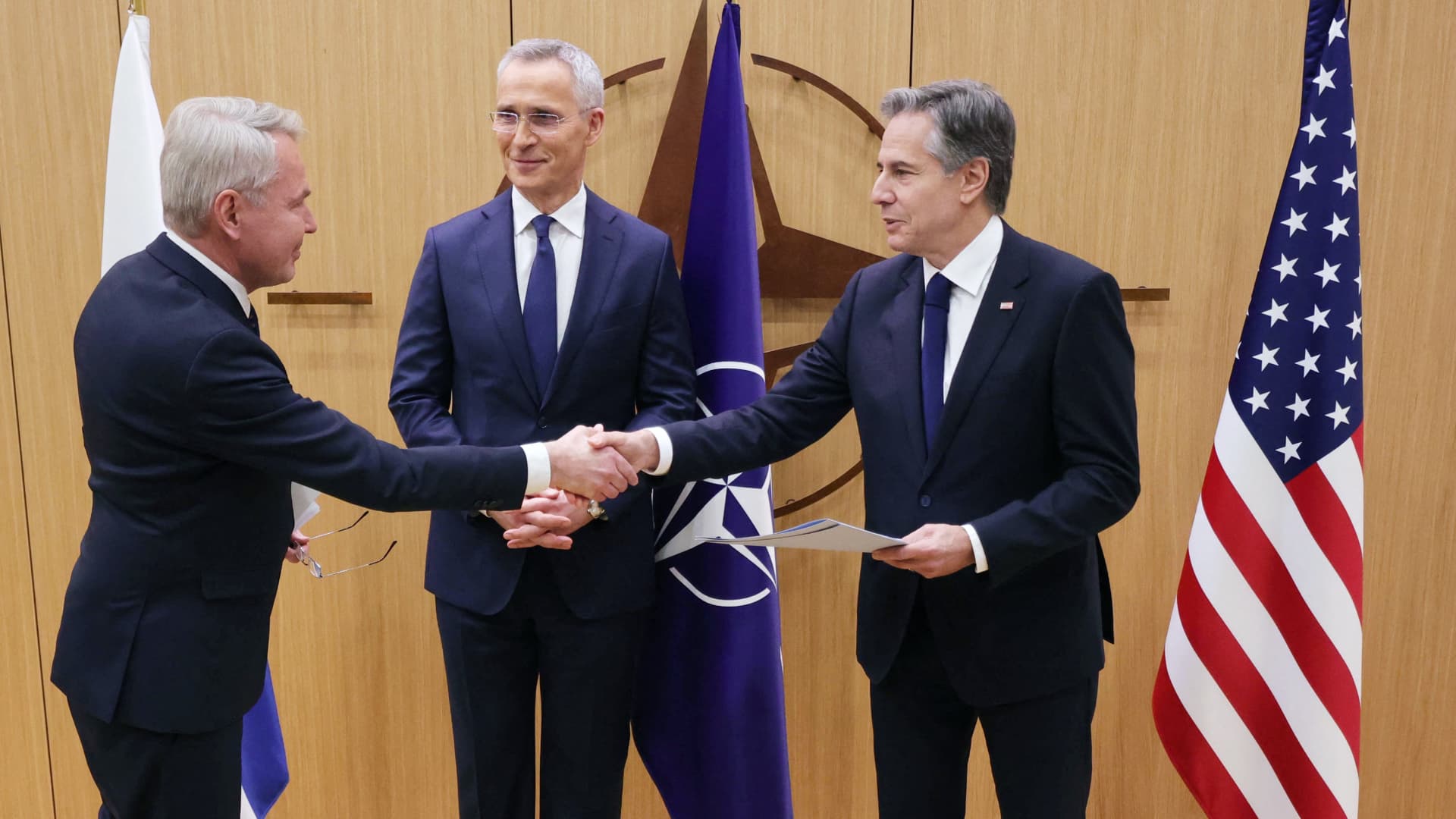 Finnish Foreign Affairs Minister Pekka Haavisto (L) shakes hands with US Secretary of State Antony Blinken, flanked by NATO Secretary-General Jens Stoltenberg (C) as he hands over Finland's accession to NATO documents, during a joining ceremony at a NATO - North Atlantic Council (NAC) Foreign Affairs ministers' meeting, at the NATO headquarters in Brussels, on April 4, 2023. - Finland on April 4 became the 31st member of NATO, wrapping up its historic strategic shift with the deposit of its accession documents to the alliance. 