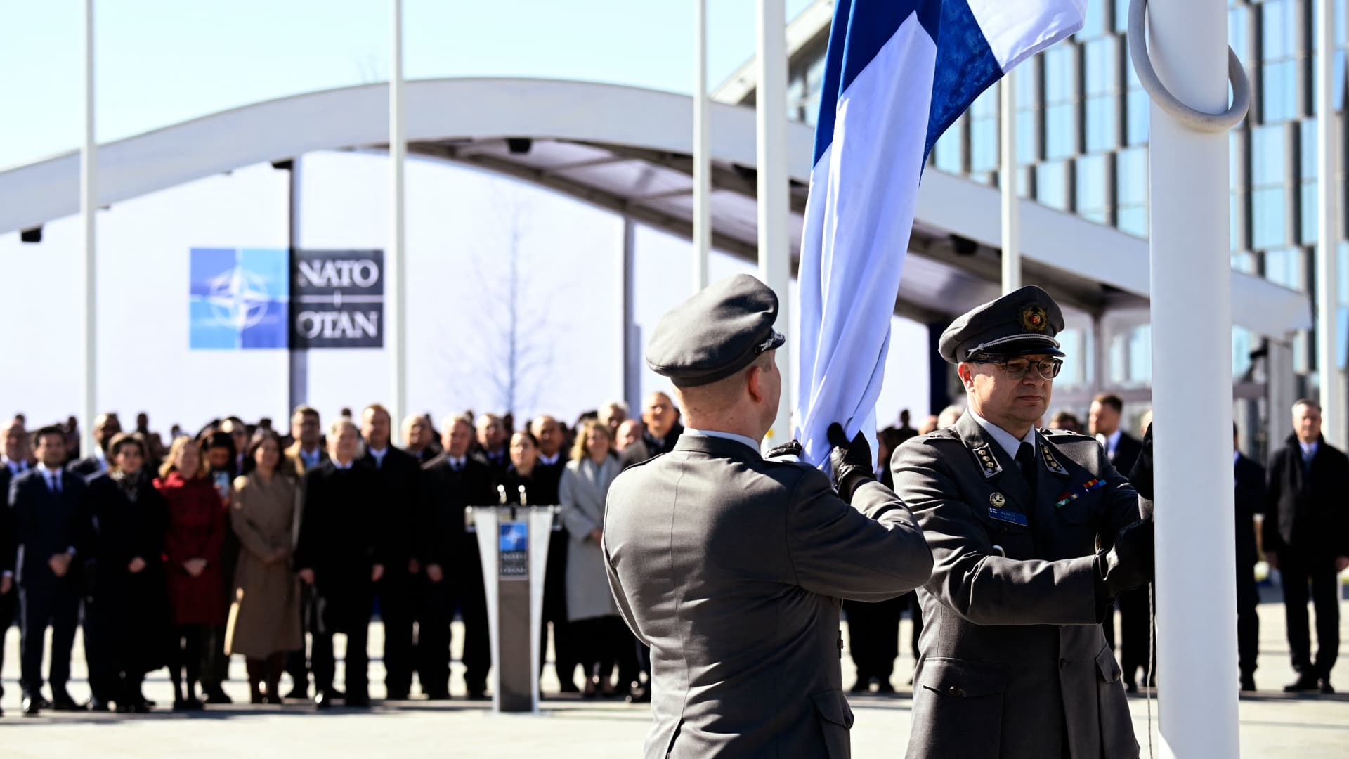 Finnish military personnel install Finland's national flag at the NATO headquarters in Brussels, on April 4, 2023.