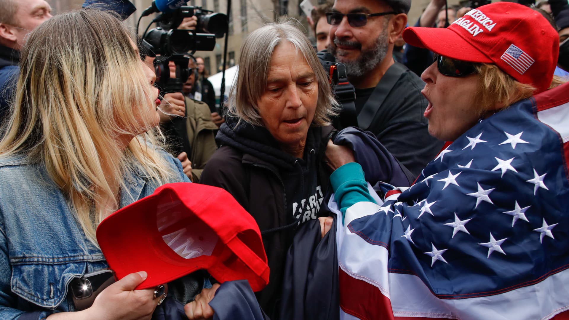 Trump supporters argues with an Anti-Trump protester (C) after they removed an anti-Trump banner from her outside the Manhattan Criminal Courthouse on April 04, 2023 in New York City.
