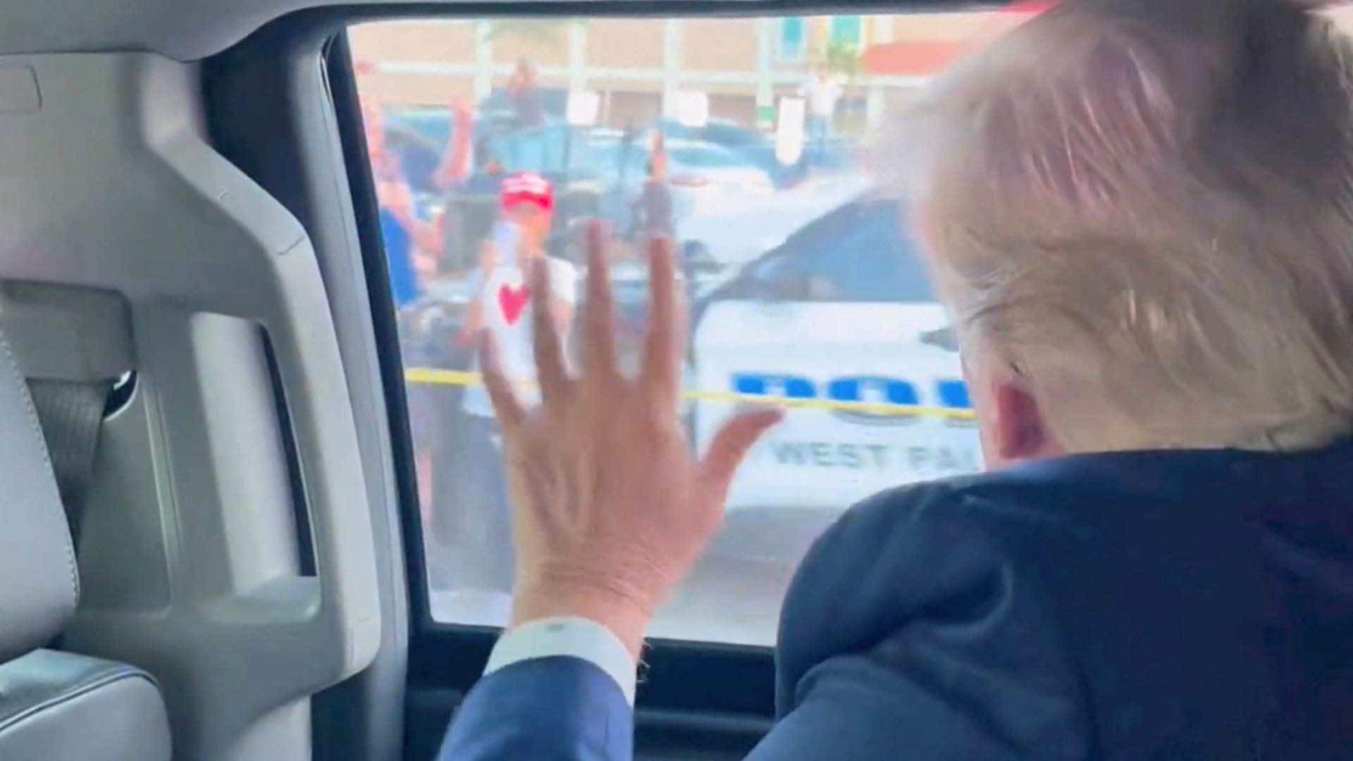 Former U.S. President Donald Trump waves to a crowd en route to his Mar-a-Lago resort after being indicted by a Manhattan grand jury following a probe into hush money paid to porn star Stormy Daniels, in Palm Beach, Florida, on April 4, 2023.