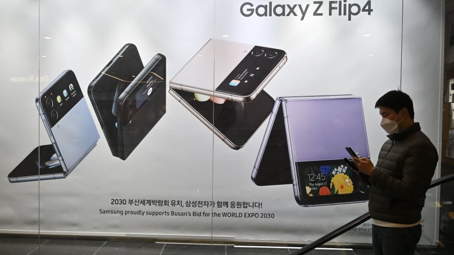 A man walks past an ad for the Samsung Galaxy Z Flip4 smartphone at the company's Seocho building in Seoul on Jan. 31, 2023.