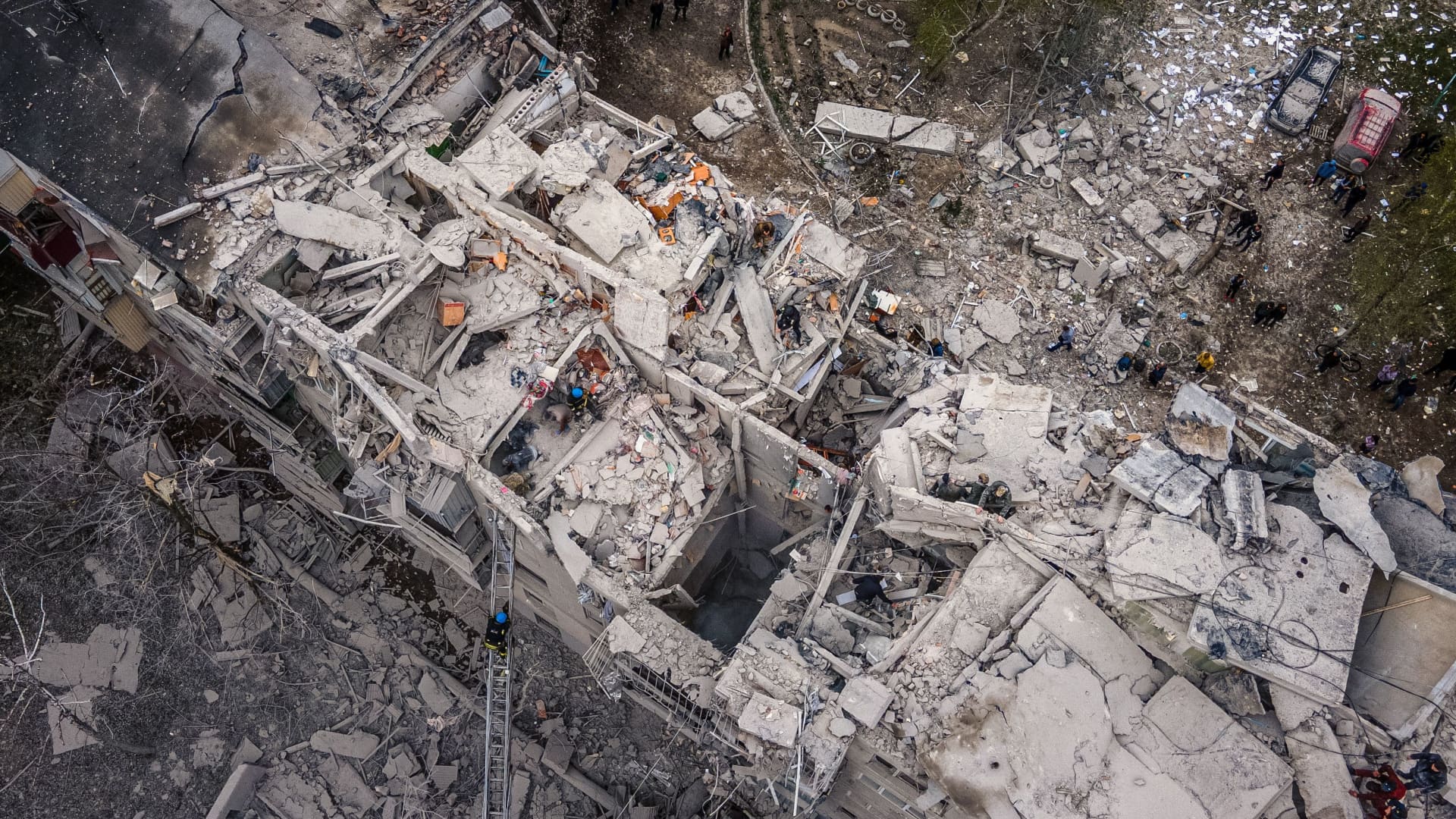 This aerial view shows rescuers on top of a partially destroyed residential building, after a shelling in Sloviansk, on April 14, 2023, amid Russia's military invasion on Ukraine.