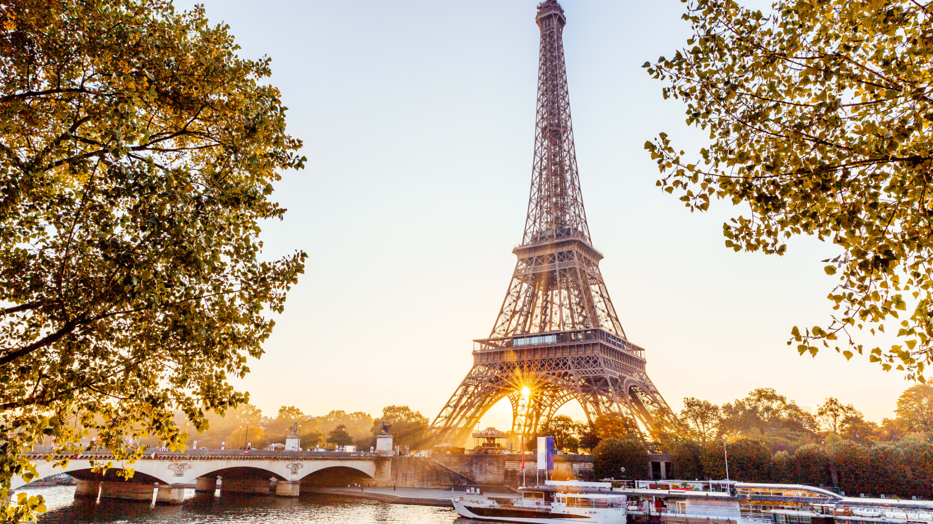 The Eiffel Tower and Seine River at sunrise in Paris.