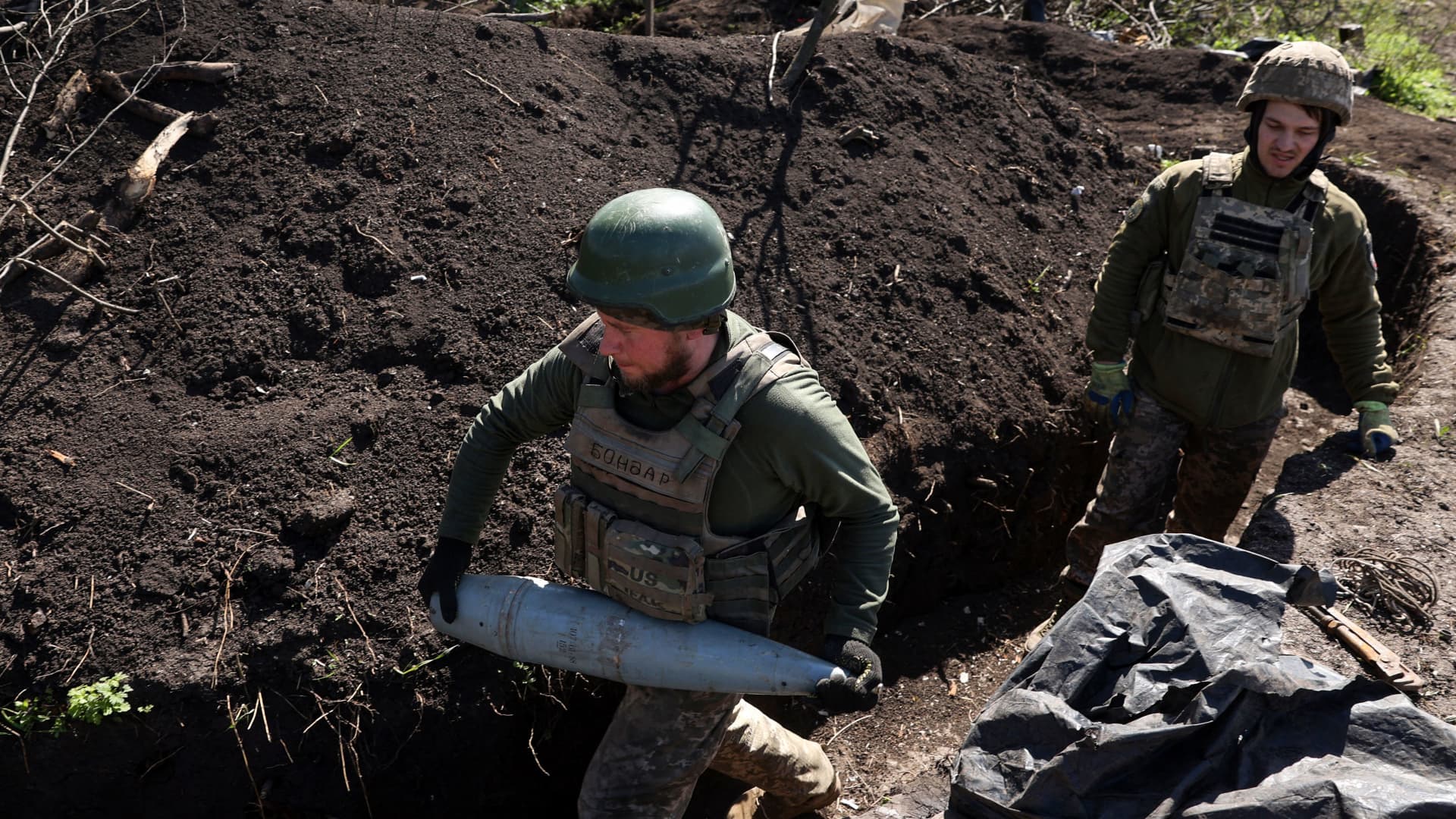 A Ukrainian artilleryman carries an artillery shell at a trench on the frontline, in Donetsk region on April 17, 2023. 