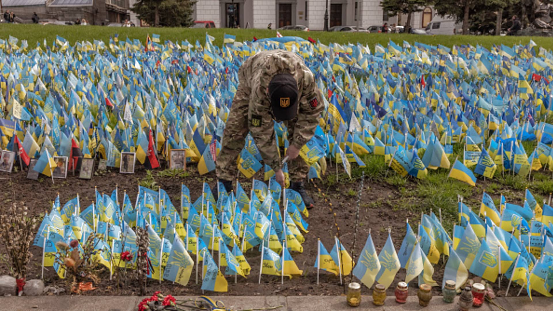 A man places Ukrainian flags which commemorate Ukrainian soldiers killed during the war with Russia, at Independence Square on April 21, 2023 in Kyiv, Ukraine.