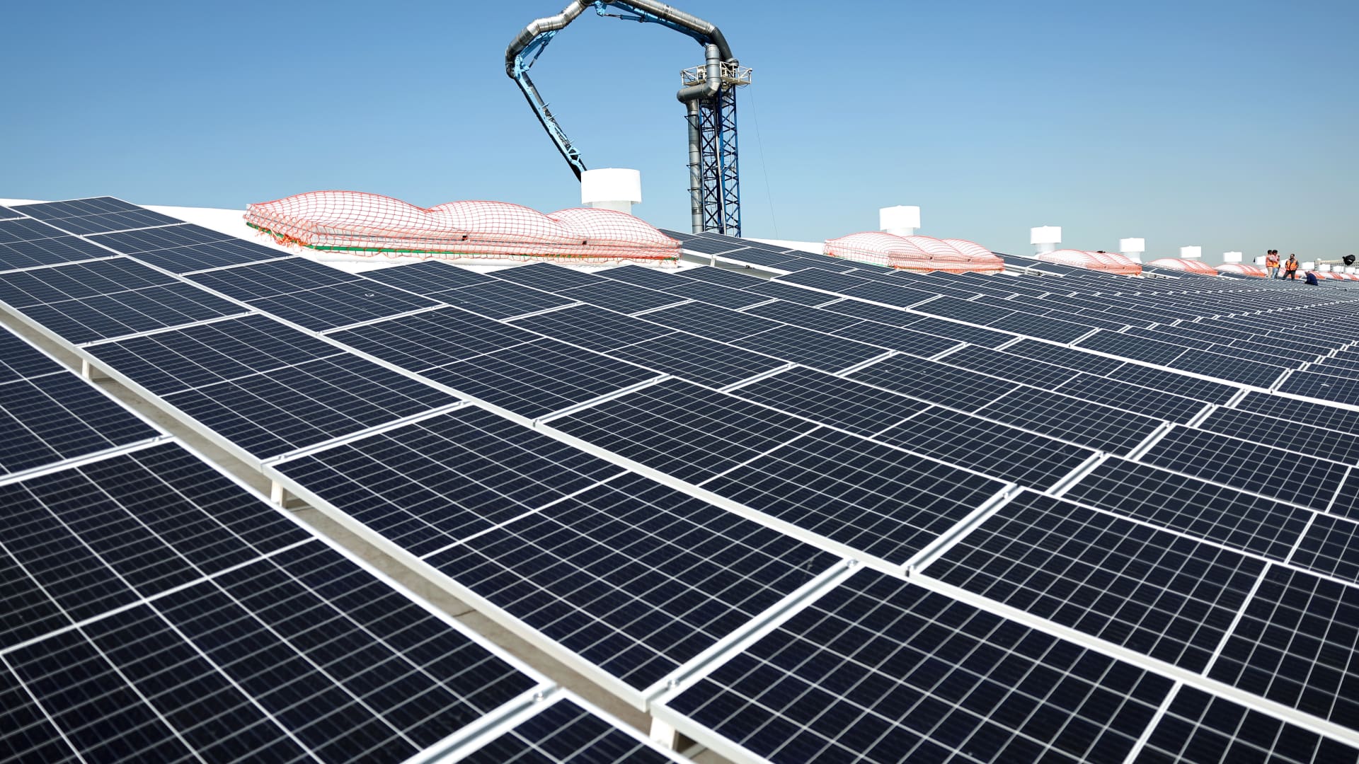 Workers install solar panels during the completion phase of a 4-acre solar rooftop atop AltaSea's research and development facility at the Port of Los Angeles, in the San Pedro neighborhood, on April 21, 2023 in Los Angeles, California.