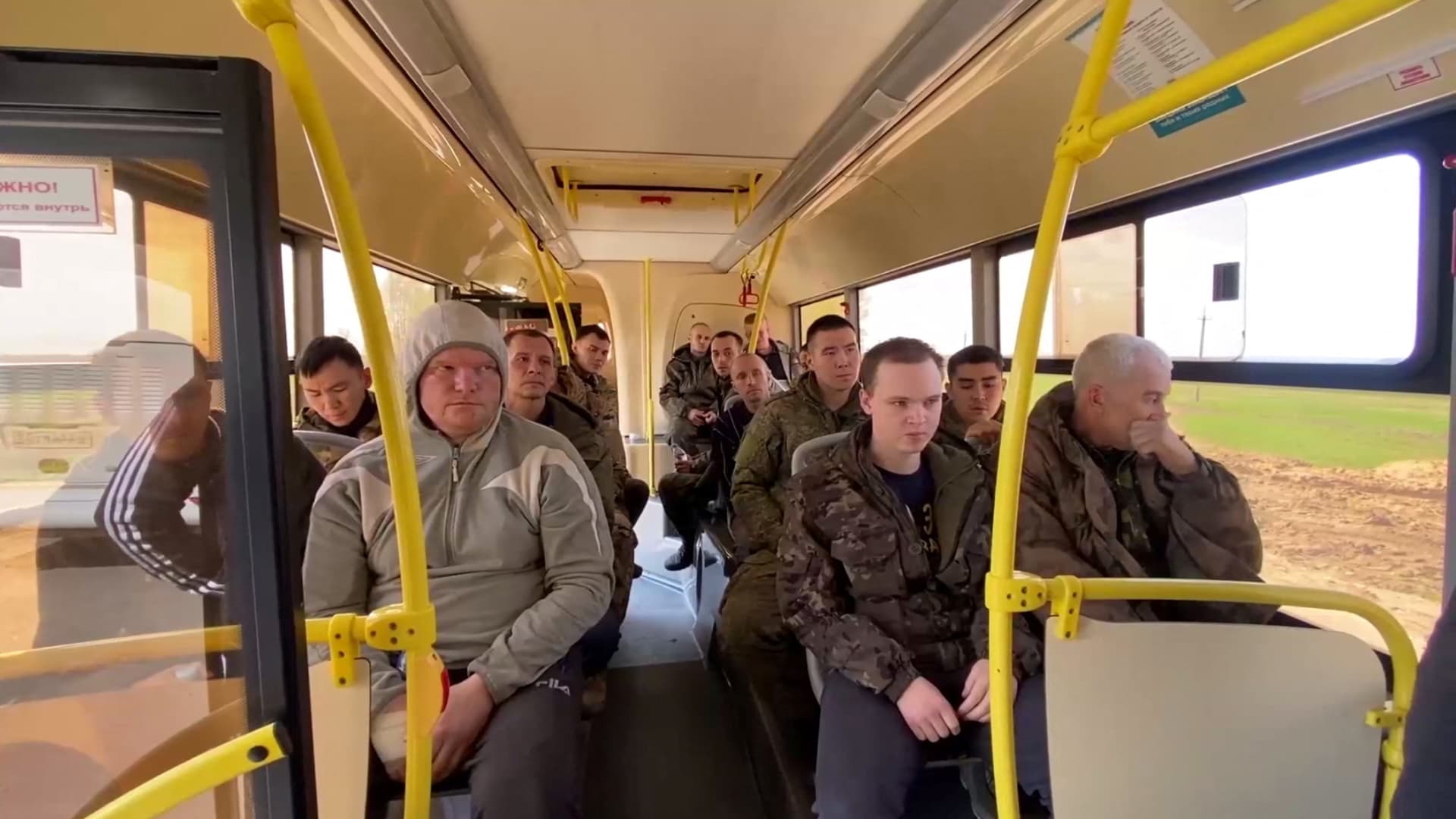 A still image from video, released by Russia's Defence Ministry, shows what it said to be captured Russian service members sitting in a bus following the latest exchange of prisoners of war in the course of Russia-Ukraine conflict, at an unknown location, in this image taken from handout footage released April 26, 2023. 