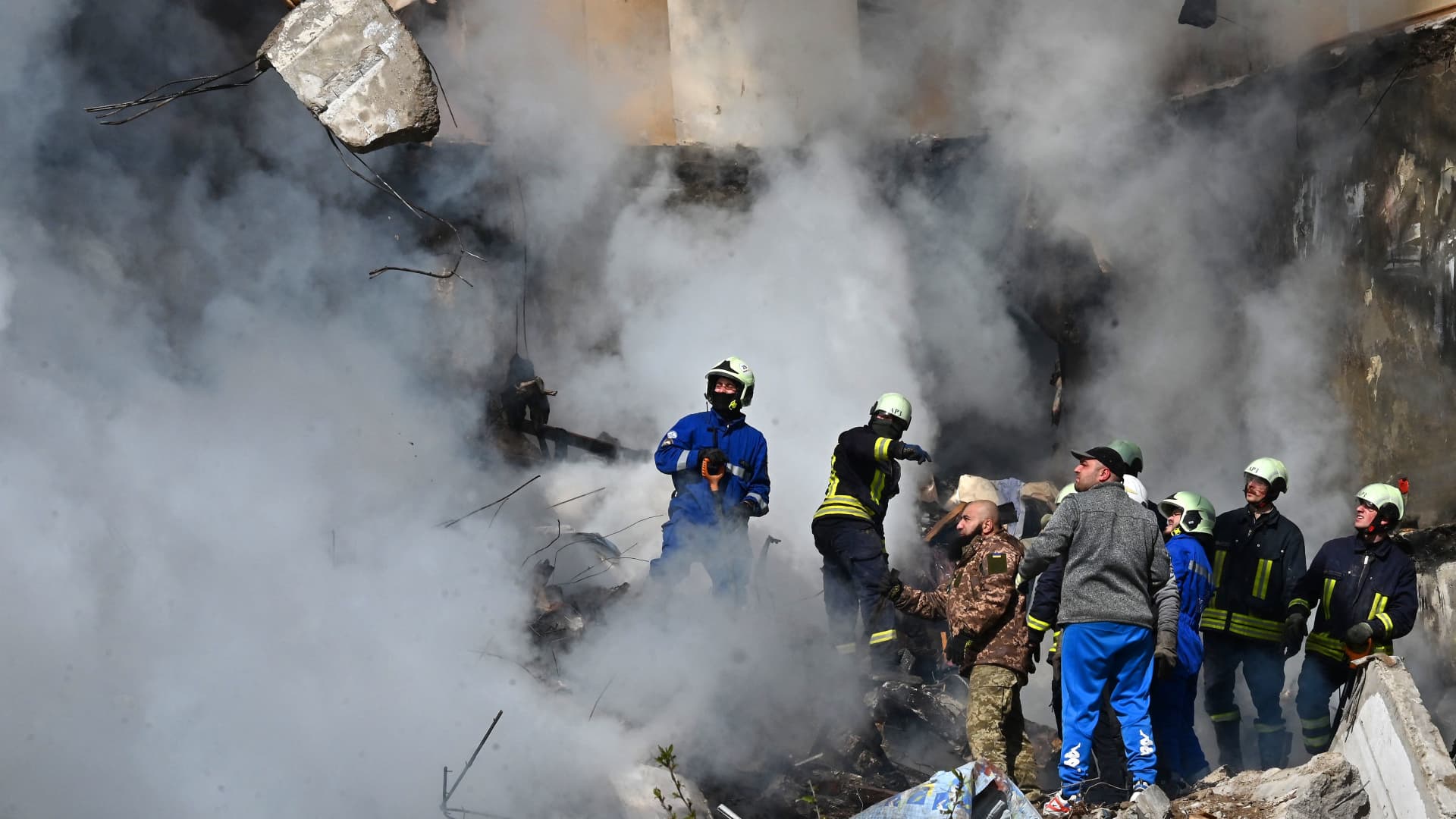 Rescuers and residents search for survivors in the rubble next to a damaged residential building in Uman, around 215km south of Kyiv, on April 28, 2023, after Russian missile strikes targeted several Ukrainian cities overnight. 
