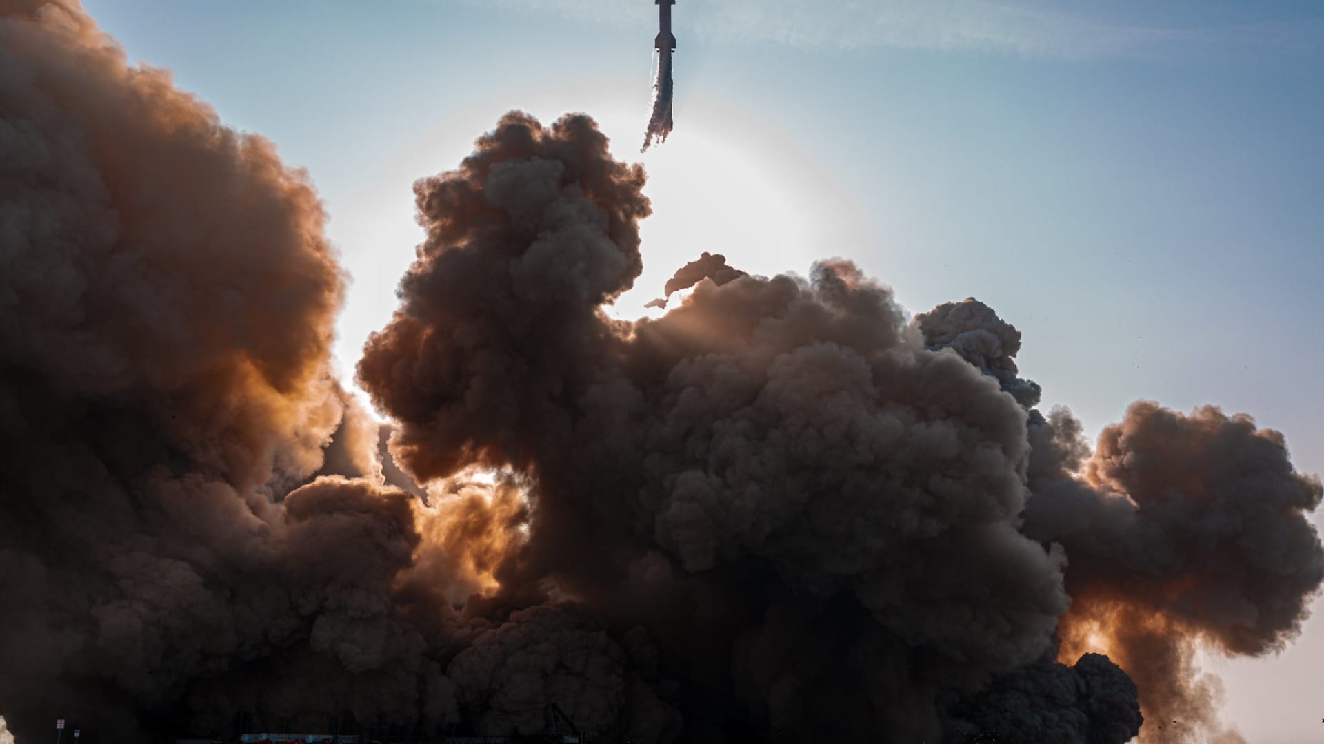 A dust cloud grows underneath Starship as the rocket launches on its Super Heavy booster from Texas on April 20, 2023.