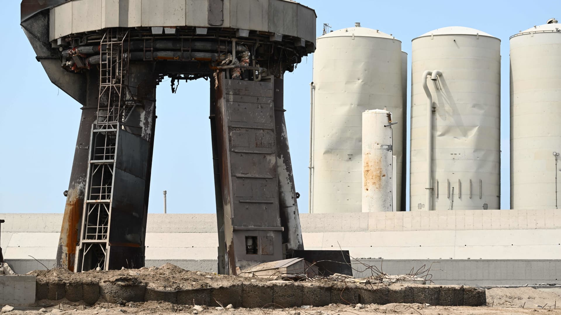 Debris litters the launch pad and dmaged tanks (R rear) on April 22, 2023, after the SpaceX Starship lifted off on April 20 for a flight test from Starbase in Boca Chica, Texas.