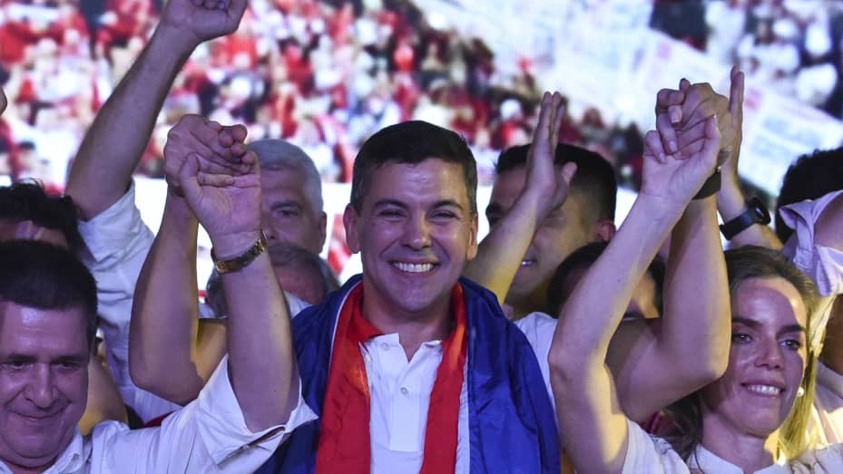 El candidato presidencial paraguayo por el Partido Colorado, Santiago Peña (C), celebra con su esposa, Leticia Ocampos de Pea (R), y el expresidente paraguayo Horacio Cartes, después de ganar las elecciones presidenciales en Asunción el 30 de abril de 2023.