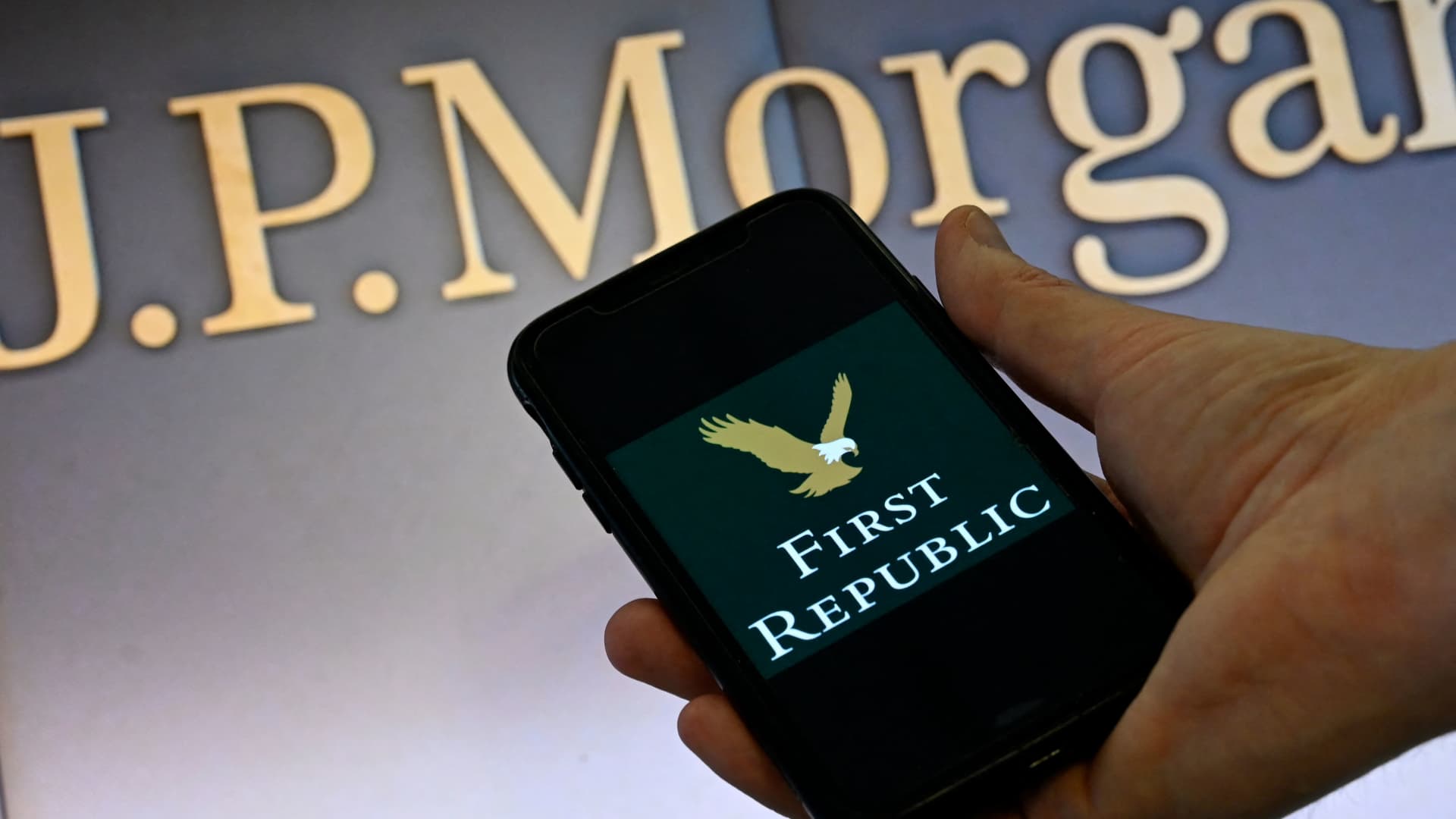 This illustration photo shows a smart phone screen displaying the logo of First Republic Bank, with a screen showing the logo of JP Morgan Chase in the background in Washington, DC on May 01, 2023.