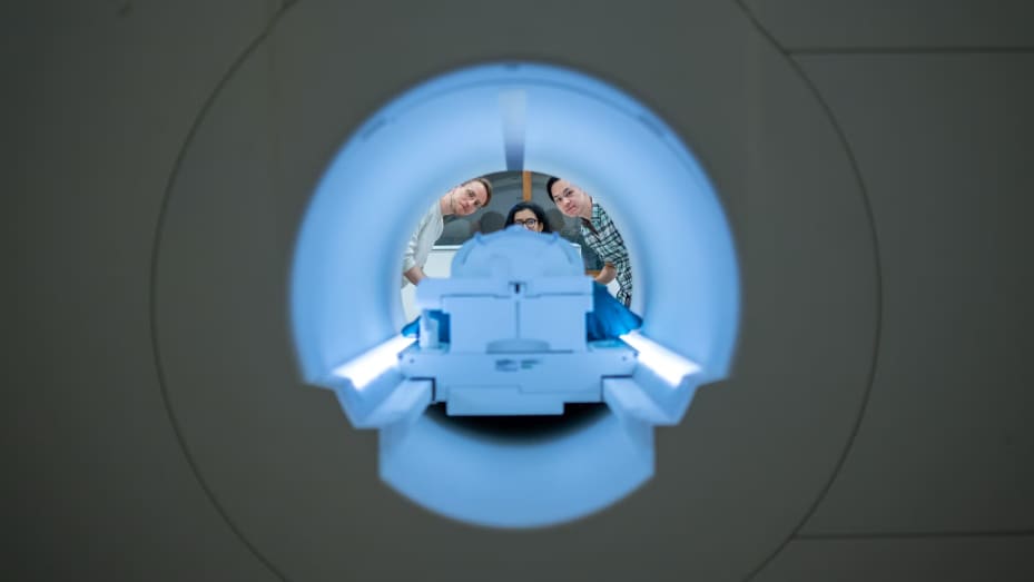 Alex Huth (left), Shailee Jain (center) and Jerry Tang (right) prepare to collect brain activity data in the Biomedical Imaging Center at The University of Texas at Austin. The researchers trained their semantic decoder on dozens of hours of brain activity data from participants, collected in an fMRI scanner. 