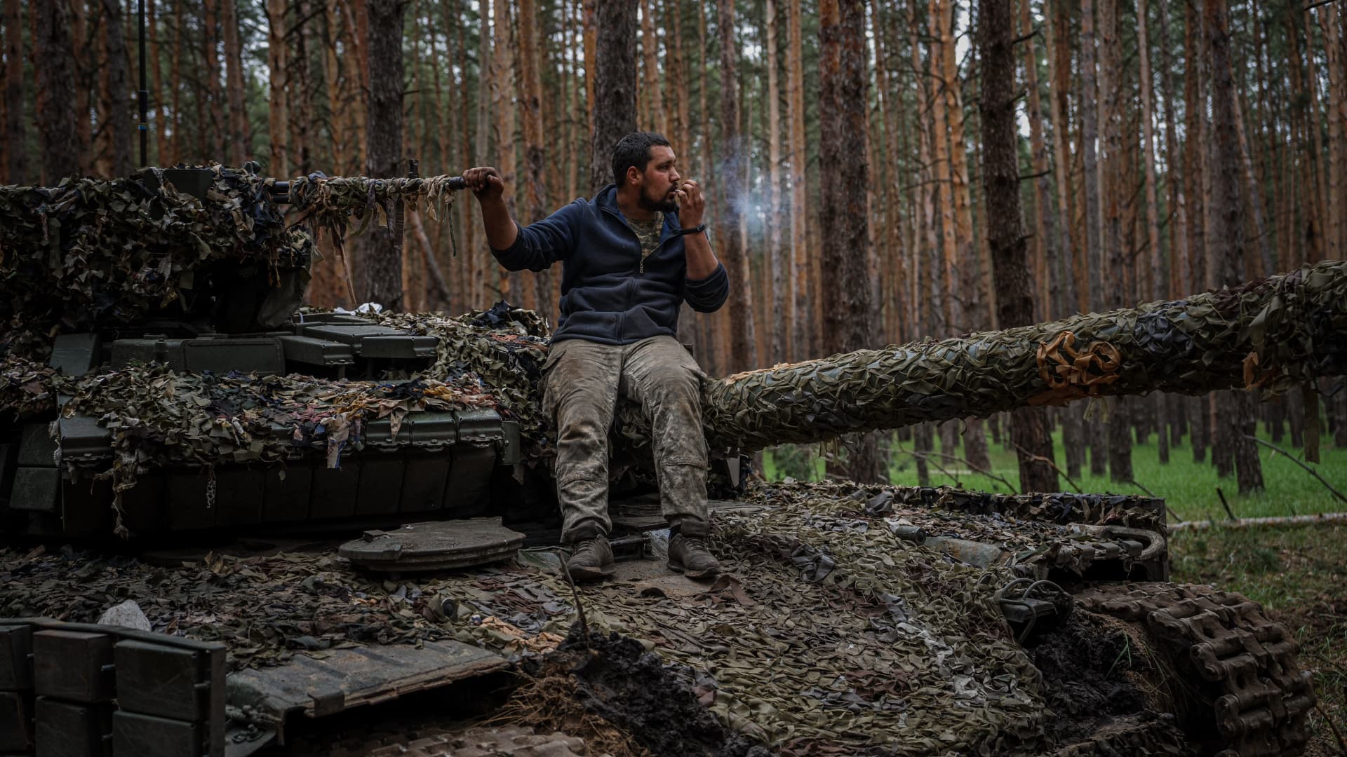 A Ukrainian tank serviceman smokes a cigarette on his tank during a military exercise in the Kharkiv region on May 1, 2023, amid the Russian invasion of Ukraine. 