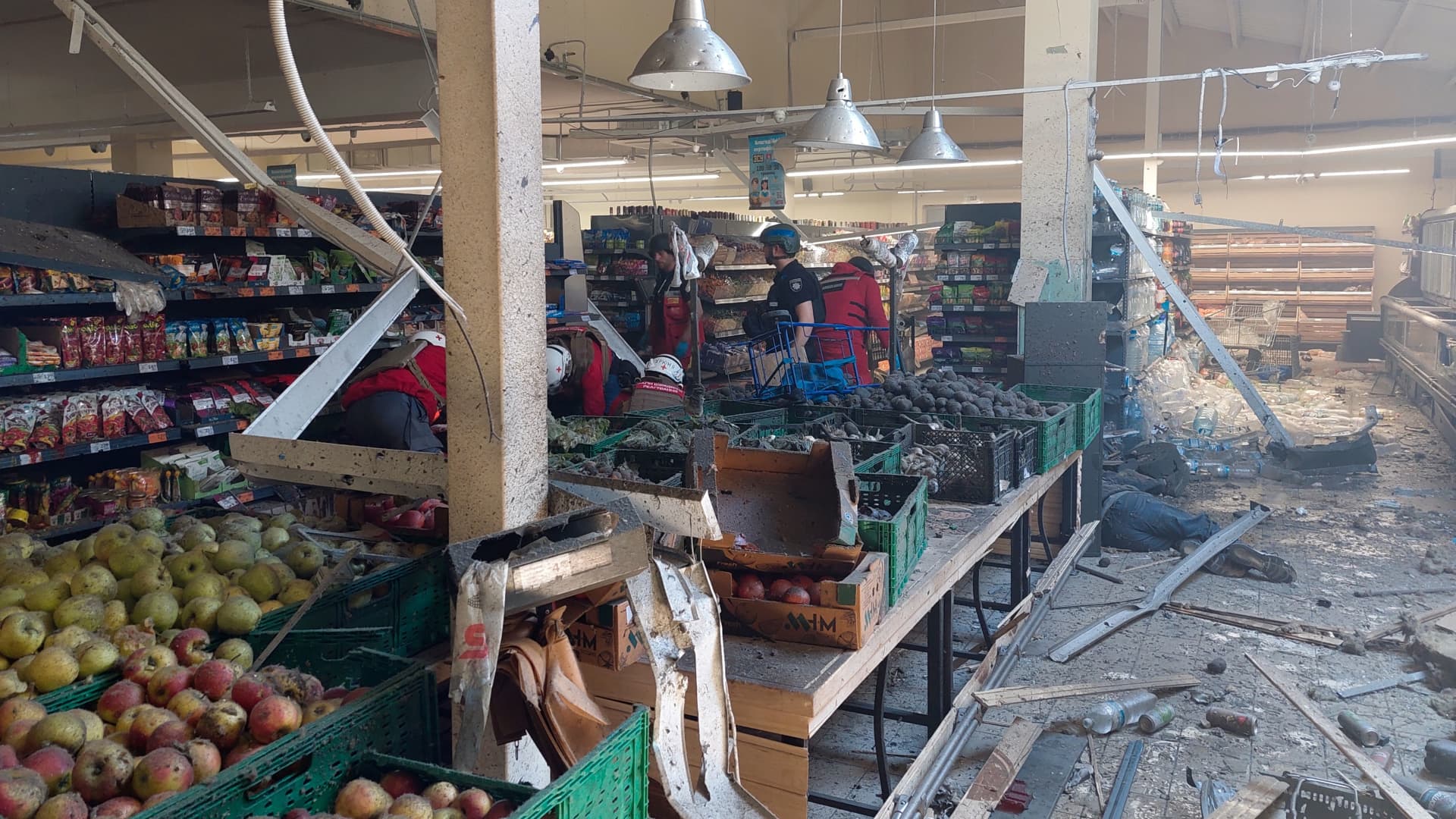 EDITORS NOTE: Graphic content / Policemen stand next to the bodies of local residents covered with a blanket in front of a damaged hypermarket in the southern Ukrainian city of Kherson, amid the Russian invasion of Ukraine.