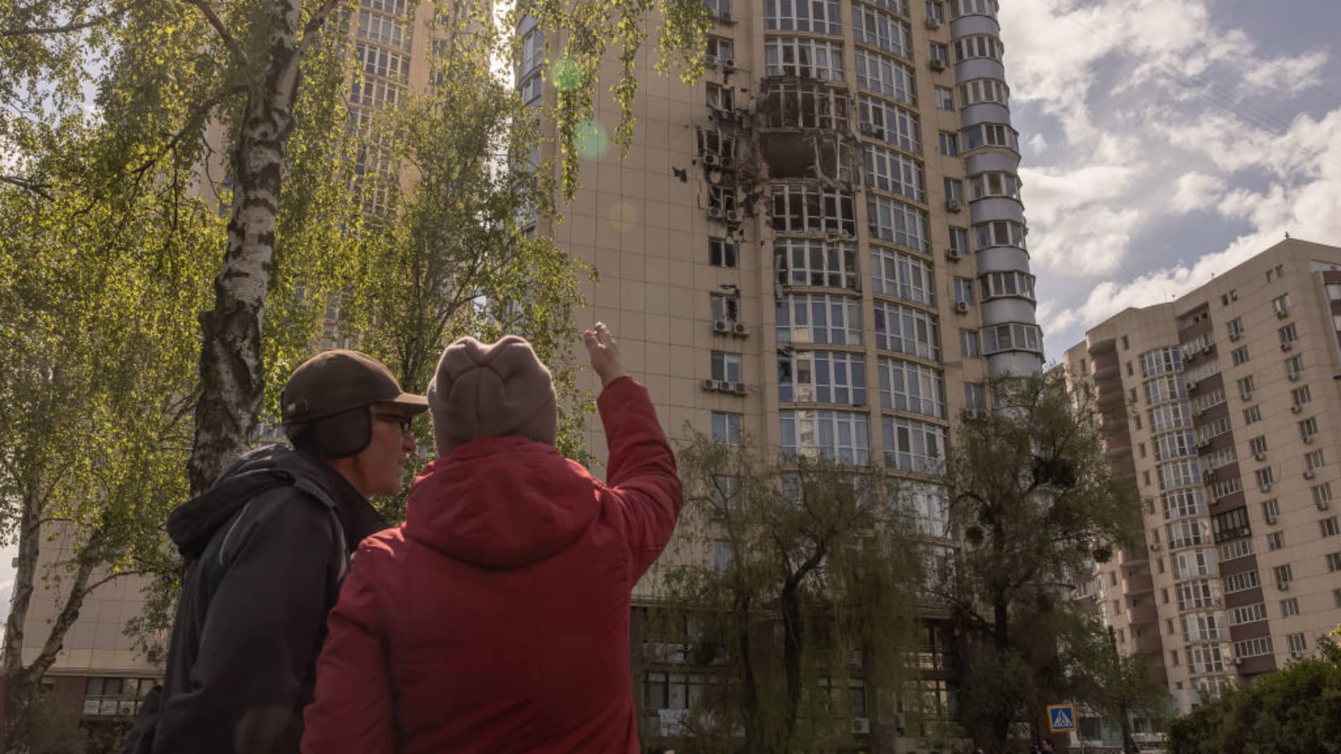 People look at a residential building damaged by the debris of a Russian intercepted drone, on May 8, 2023 in Kyiv, Ukraine.