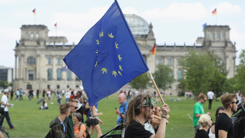 Activists demanding the legalization of marijuana, including on a flag of the European Union with its stars replaced by marijuana leaves, march past the Reichstag during the annual Hemp Parade in Berlin, Germany.