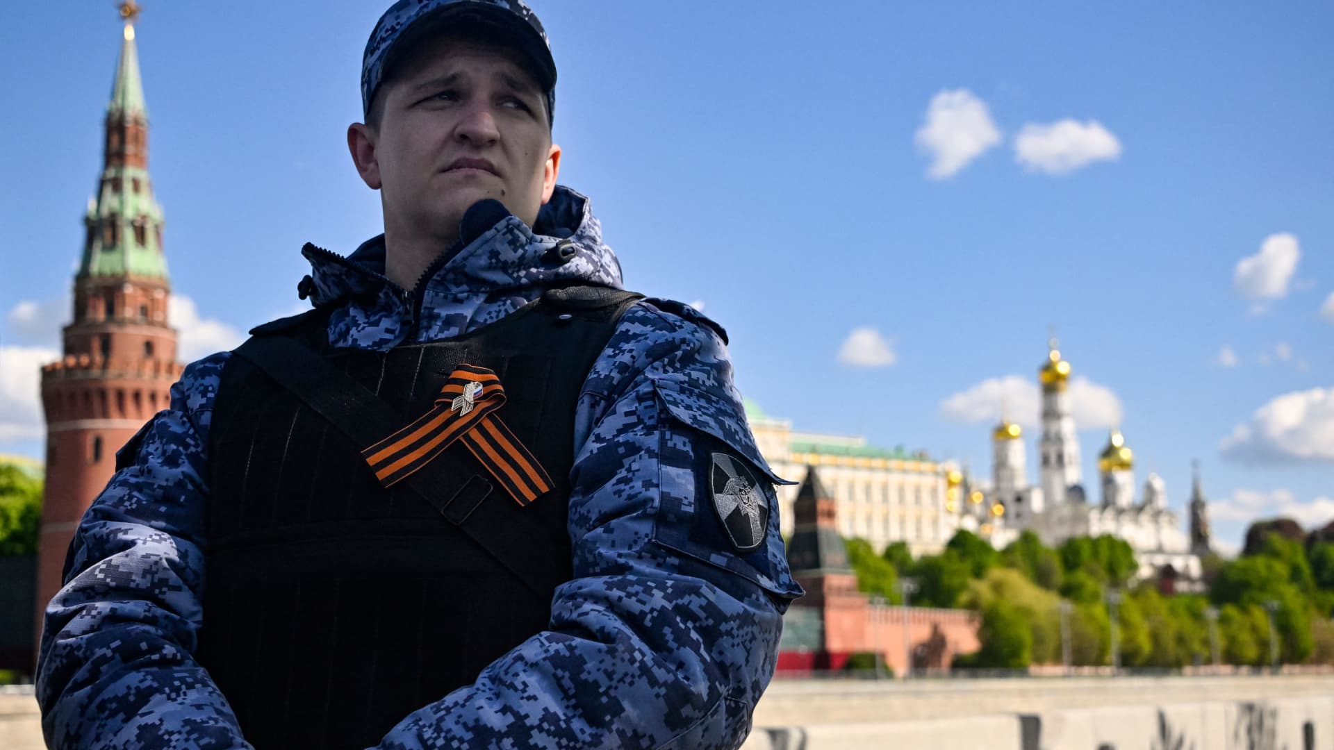 A Russian National guard serviceman stands guard at an embankment of the Moskva river opposite the Kremlin on the morning of the Victory Day military parade.