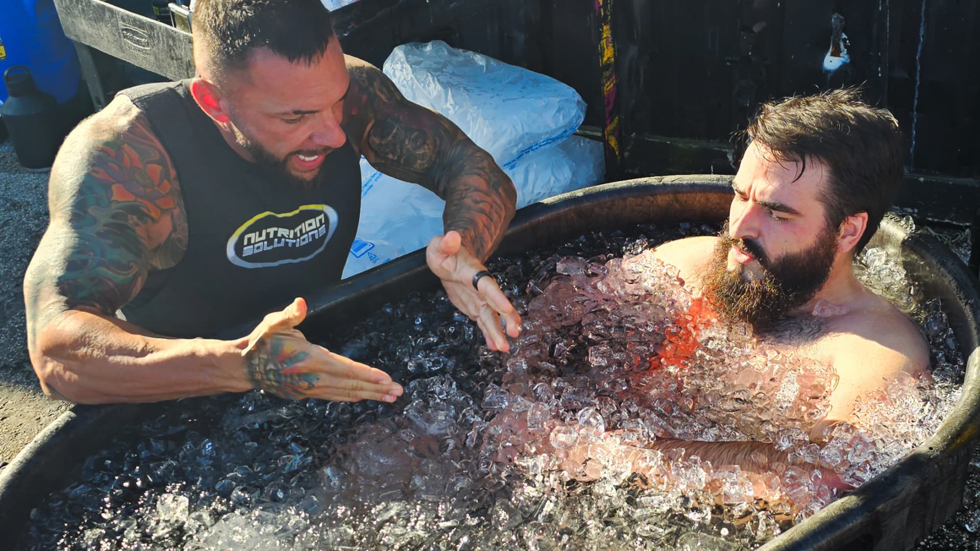 Chris Cavallini, CEO of Nutrition Solutions, guiding one of his employees during an ice bath session.