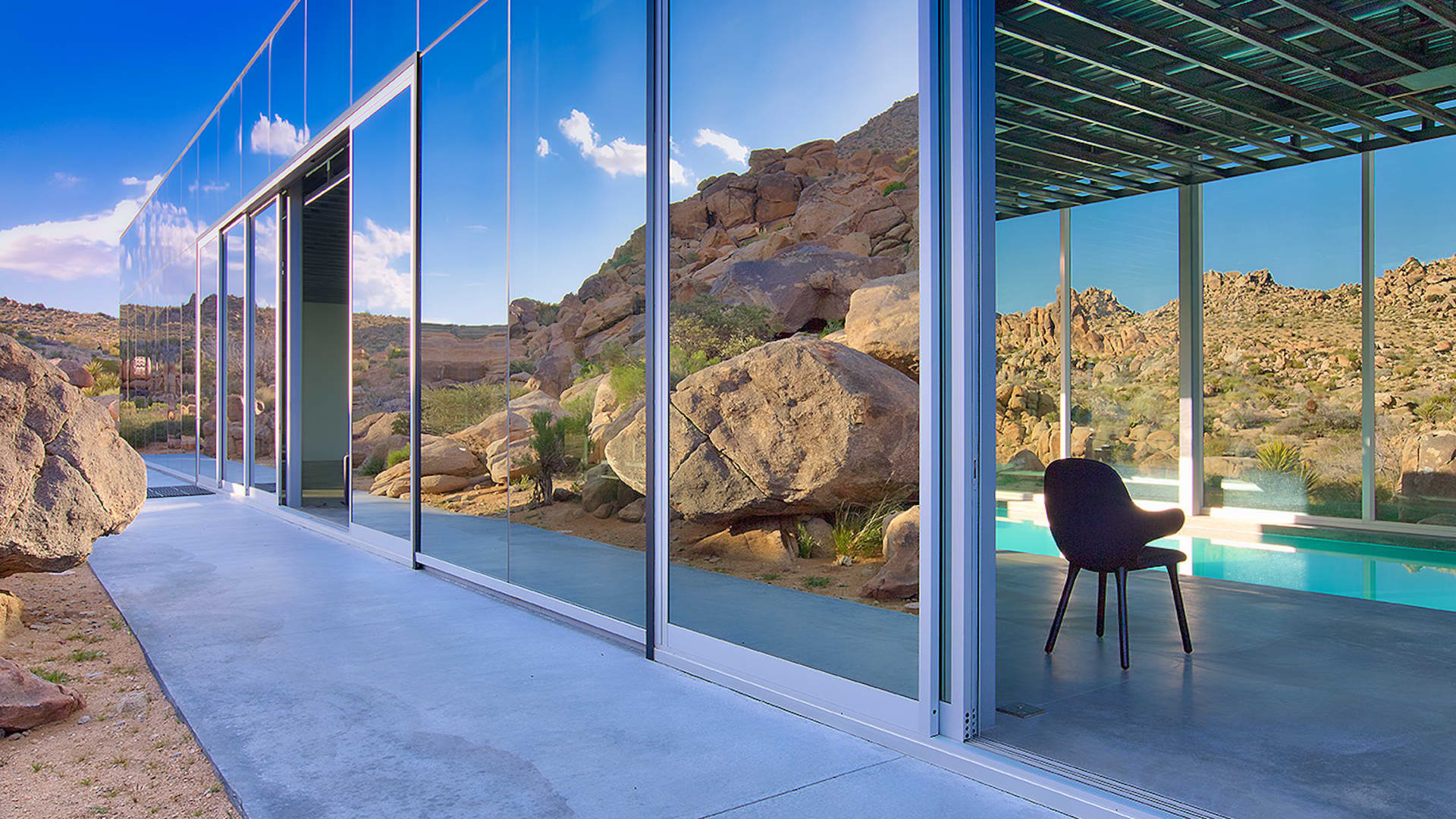 The home's west-facing glass wall slides open to the desert landscape.