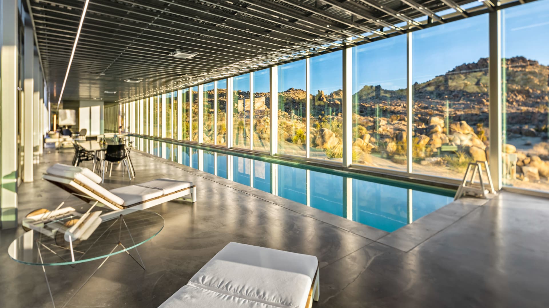 A view of the indoor pool and the panoramic views framed by floor-to-ceiling panels of glass.