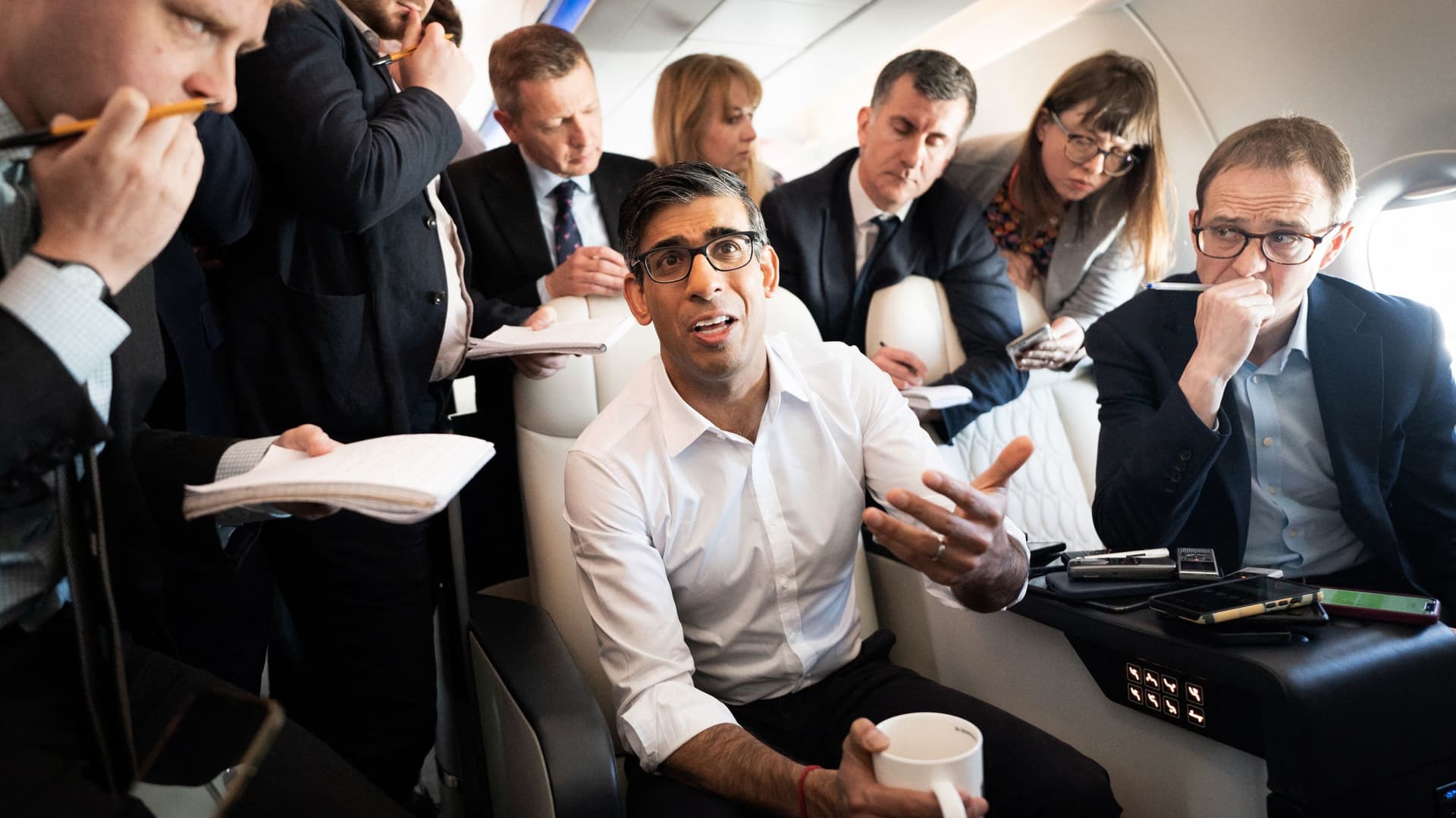 British Prime Minister Rishi Sunak speaking to political journalists on board a government plane as he heads to Japan to attend the Group of Seven summit in Hiroshima, on May 17, 2023.