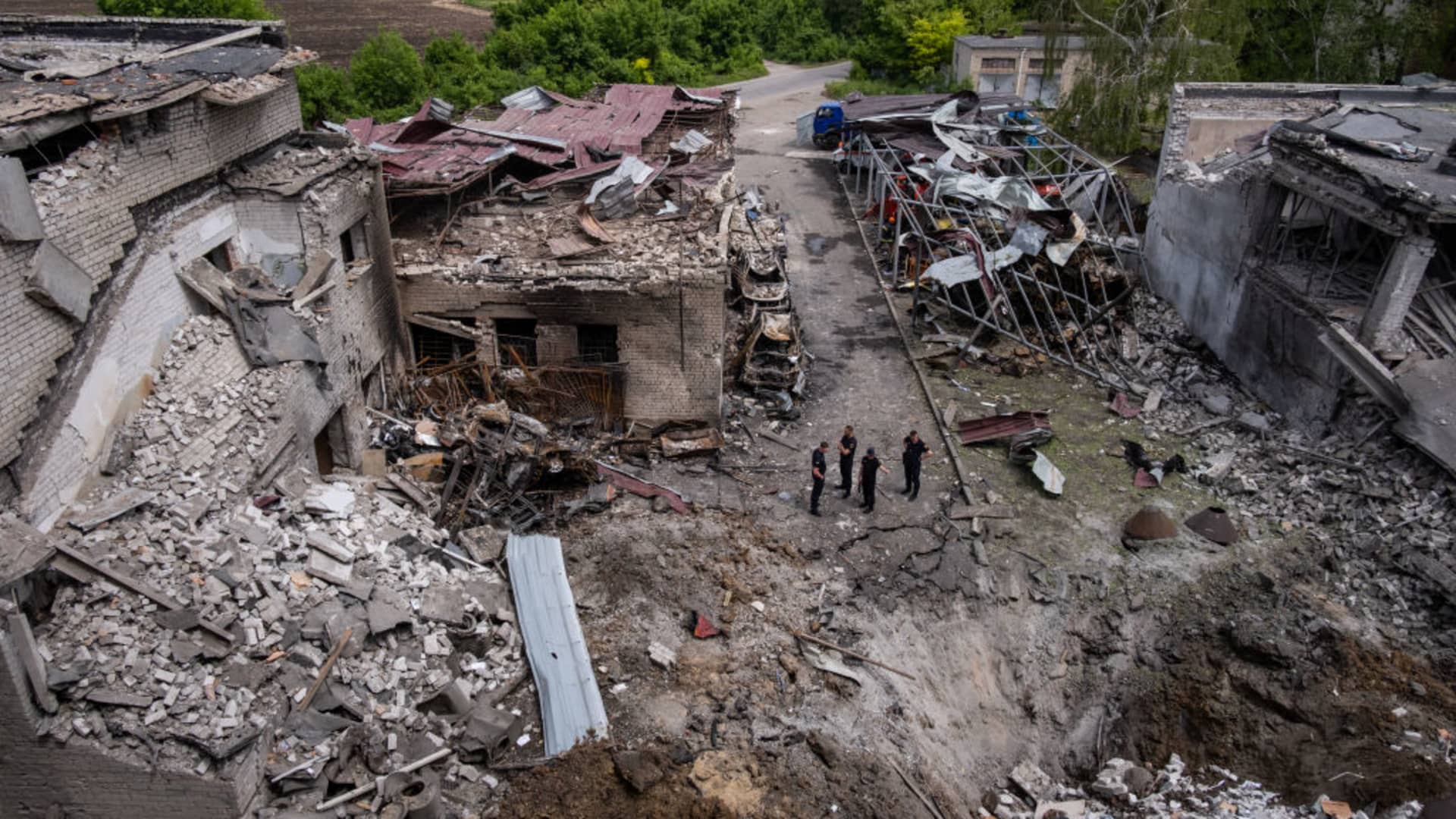 Ukrainian firefighters observe the crater left behind by a missile strike at a building that housed a fire station and a laboratory that was struck overnight in a round of fresh strikes in Dnipro city in the Dnipropetrovsk region, Ukraine on May 22, 2023.