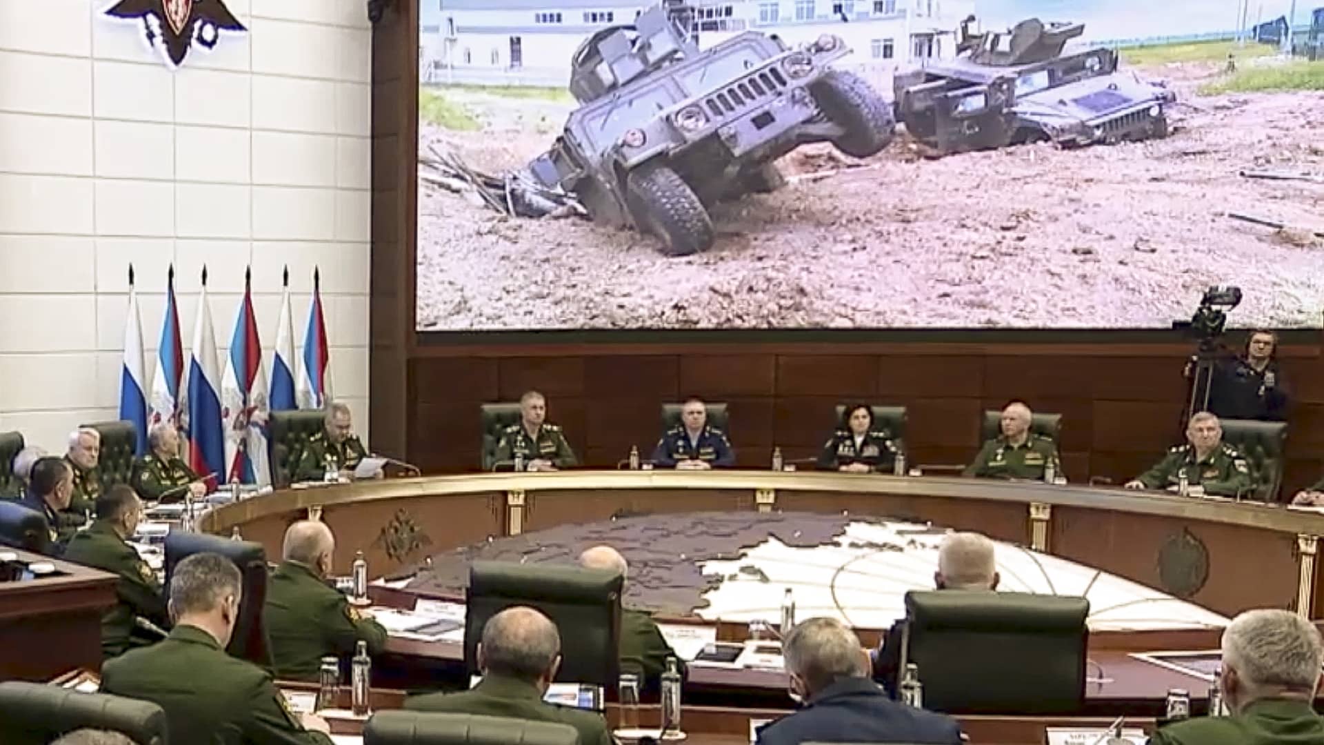 In this handout photo taken from video released by Russian Defense Ministry Press Service, Russian Defense Minister Sergei Shoigu, fourth left in the background, speaks during a meeting with high-level officers in Moscow on Wed., May 24, 2023. Damaged Ukrainian armored military vehicle are seen after fighting in Russia's western Belgorod region.