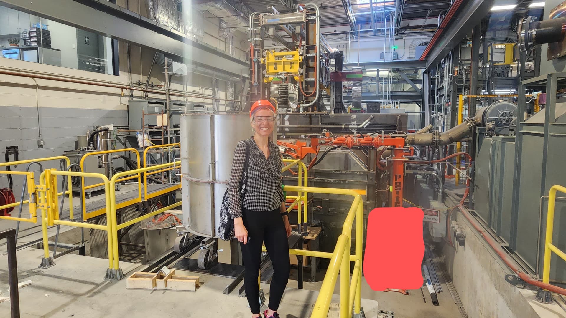 Reporter Cat Clifford stands next to Boston Metal's multi-anode electrolyzer cell. (A portion of the device has been covered to protect the intellectual property of Boston Metal.)