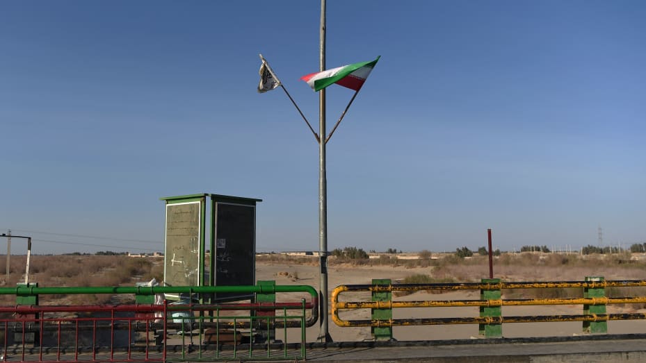 En esta foto tomada el 18 de febrero de 2022, una bandera talibán (izquierda) y una bandera iraní ondean en el punto cero del puente fronterizo entre Afganistán e Irán en Zaranj.  Los talibanes e Irán intercambiaron fuertes disparos cerca de la frontera el 27 de mayo de 2023.