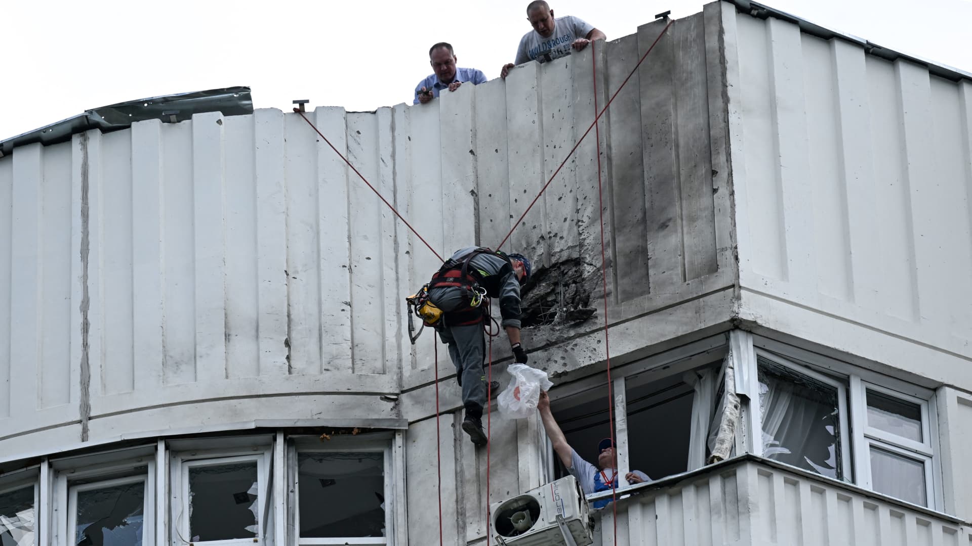 A specialist inspects the damaged facade of a multi-storey apartment building after a reported drone attack in Moscow on May 30, 2023.