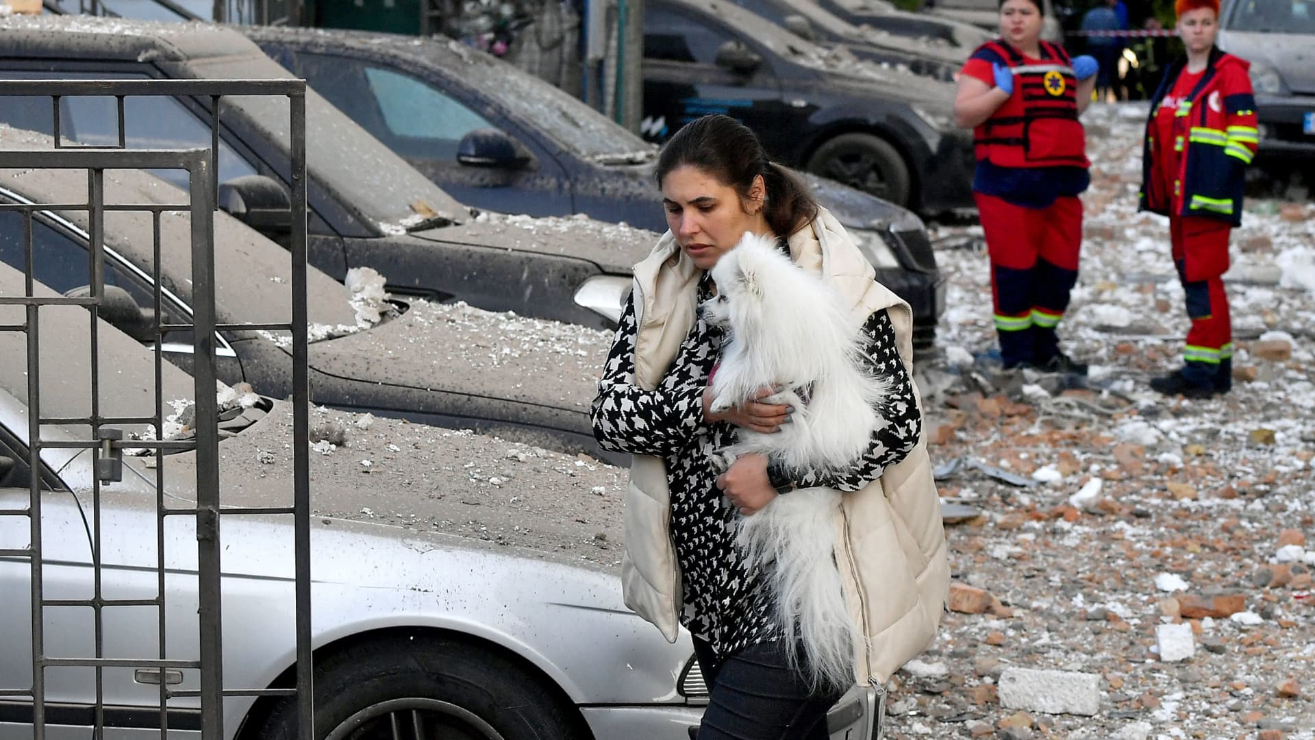 A local resident carries her dog from a multi-storey residential building, partially destroyed after night drones attack in Kyiv on May 30, 2023. Ukraine said on May 30, 2023 it had downed 29 out of 31 drones, mainly over Kyiv and the Kyiv region in the latest Russian barrage — the third on the capital in 24 hours.