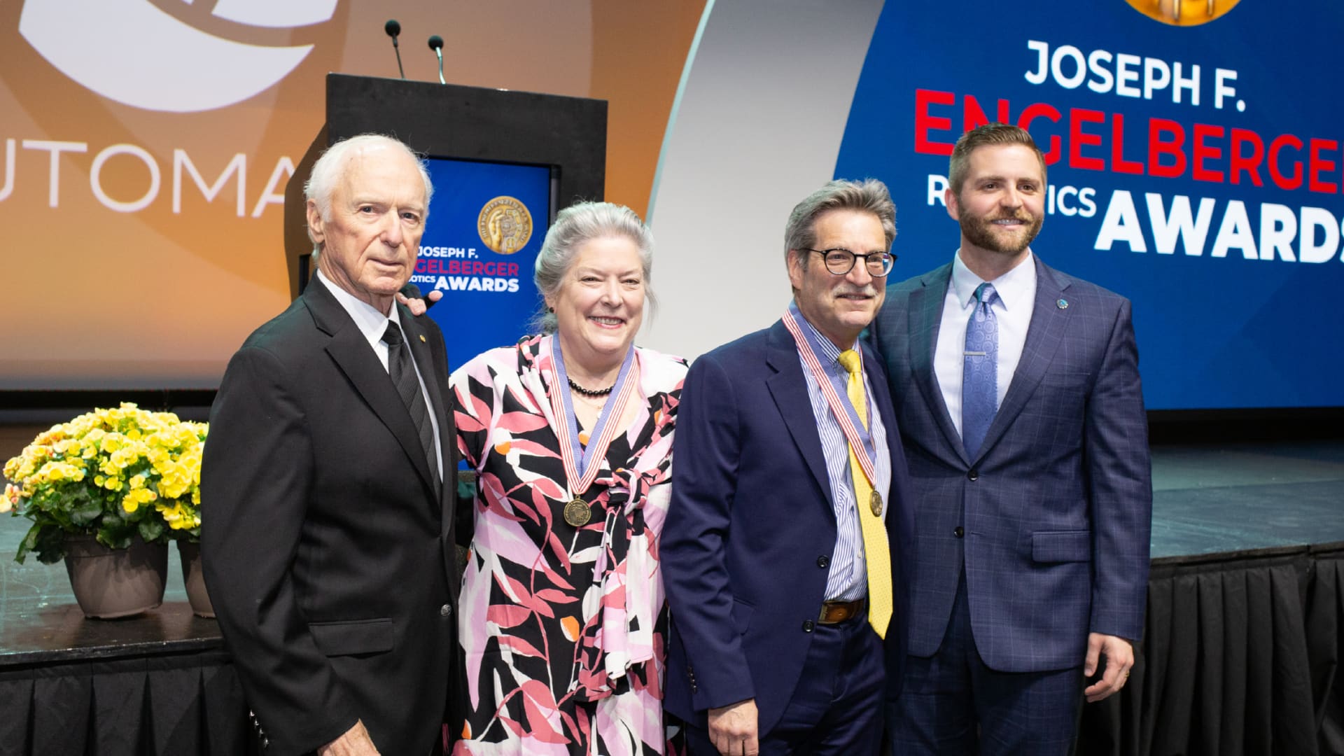 Jeff Burnstein (right center), president of the Association for Advancing Automation, after receiving a Joseph F. Engelberger Robotics Award for his more than 40-year career in the industry.
