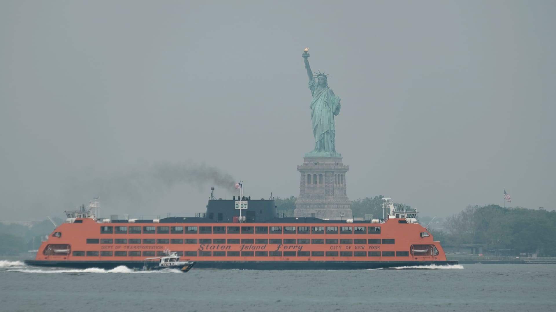 The Staten Island Ferry moves past the Statue of Liberty on a hazy morning resulting from Canadian wildfires in New York City, June 6, 2023.