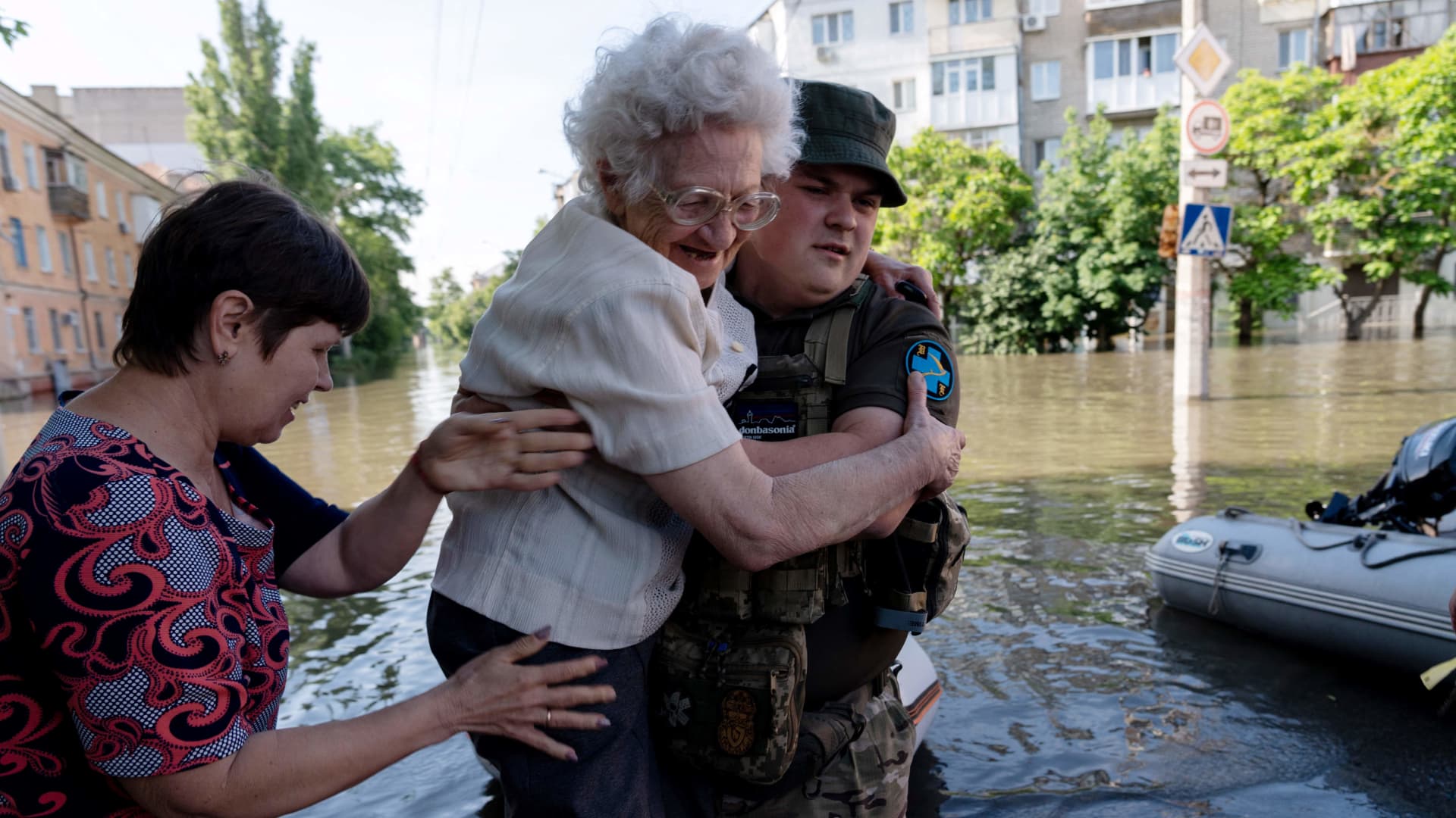 A Ukrainian serviceman helps local residents during an evacuation from a flooded area in Kherson on June 7, 2023.