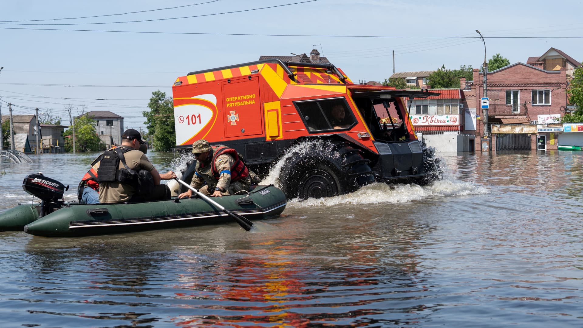 Ukrainian security forces transport local residents in a boat during an evacuation from a flooded area in Kherson on June 7, 2023, following damages sustained at Kakhovka hydroelectric power plant dam. 
