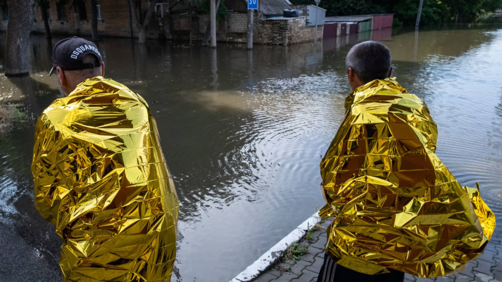 Residents of Kherson wear warming blankets after the explosion at the Kakhovka hydropower plant unleashed floodwaters in Kherson, Ukraine, on June 7, 2023.