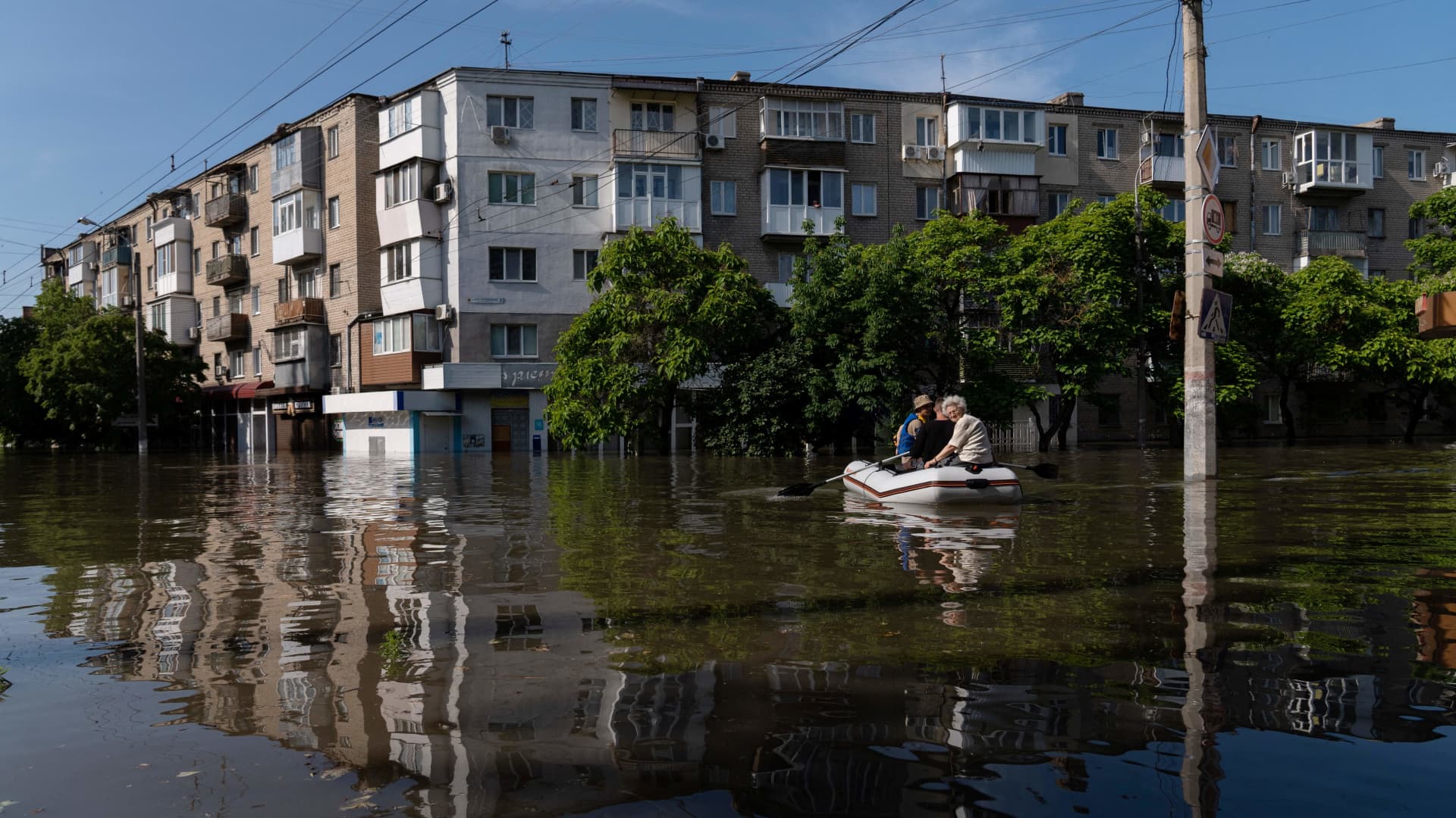 Ukrainian security forces transport local residents in a boat during an evacuation from a flooded area in Kherson on June 7, 2023, following damages sustained at the Kakhovka hydroelectric power plant dam.