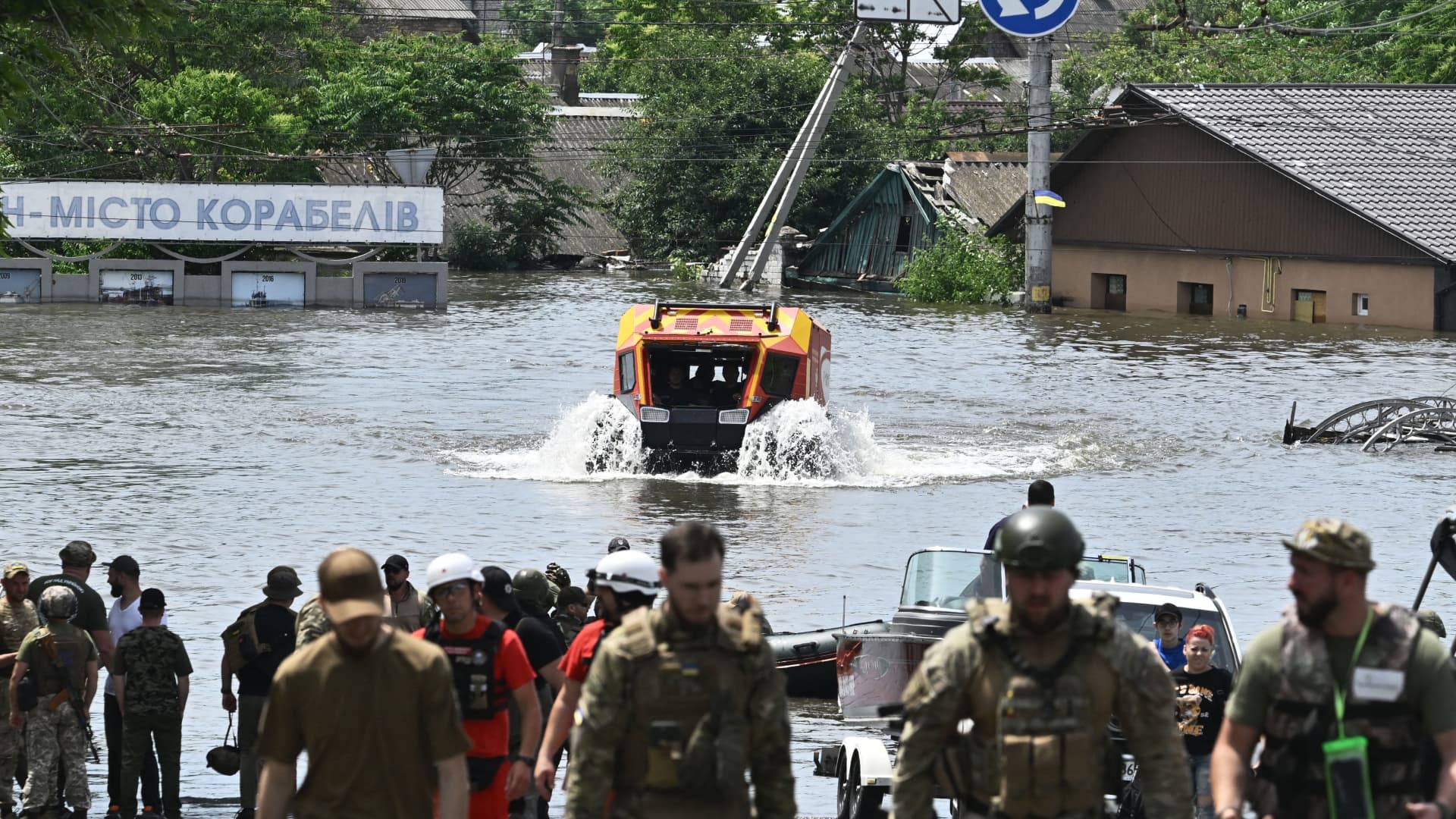 Rescuers ride an all-terrain vehicle during an evacuation from a flooded area in Kherson on June 8, 2023, following damages sustained at Kakhovka hydroelectric power plant dam. 