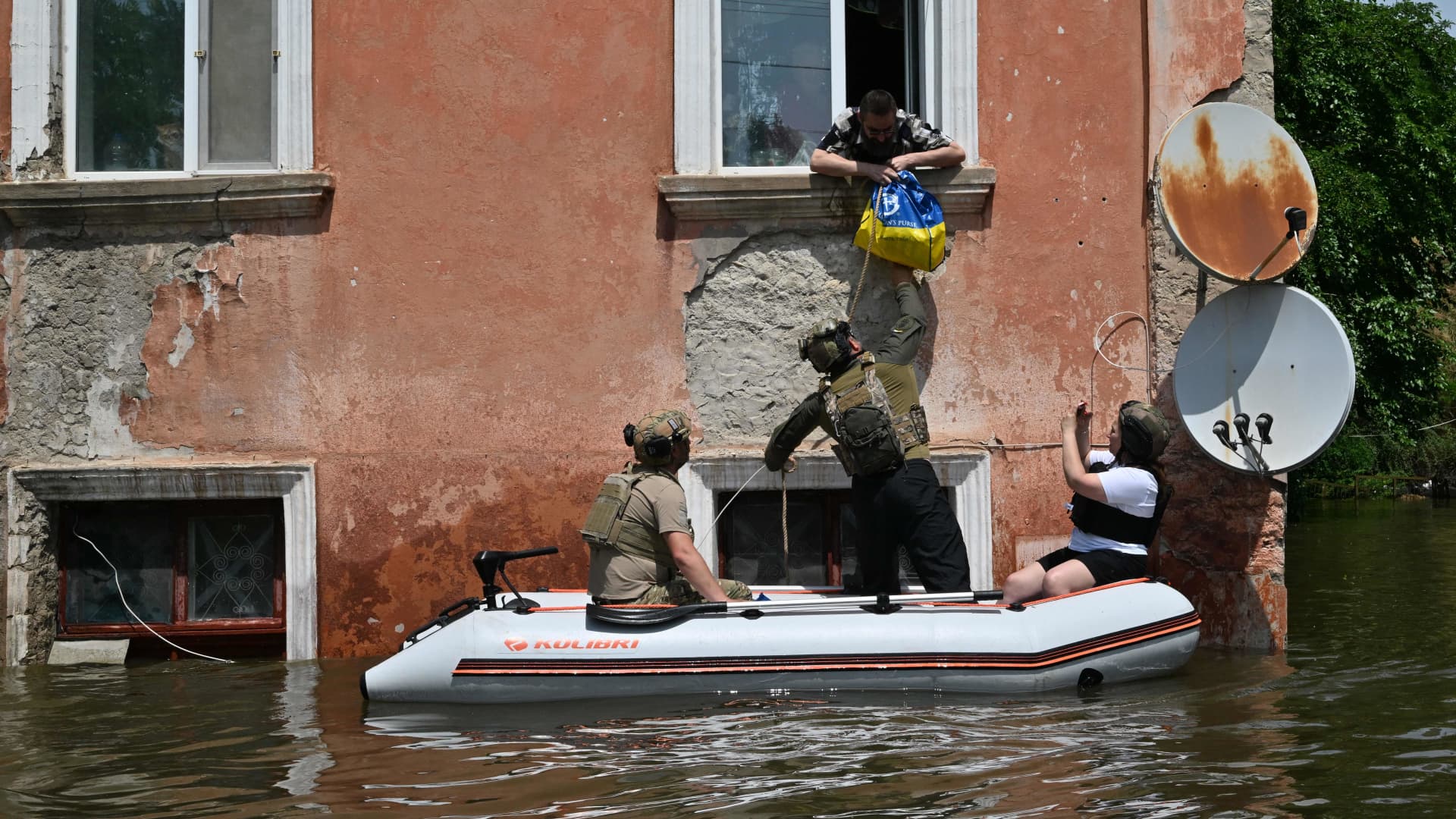 Servicemen of the National Guard of Ukraine deliver food to the residents of a flooded area in Kherson on June 8, 2023, following damages sustained at Kakhovka hydroelectric power plant dam. 