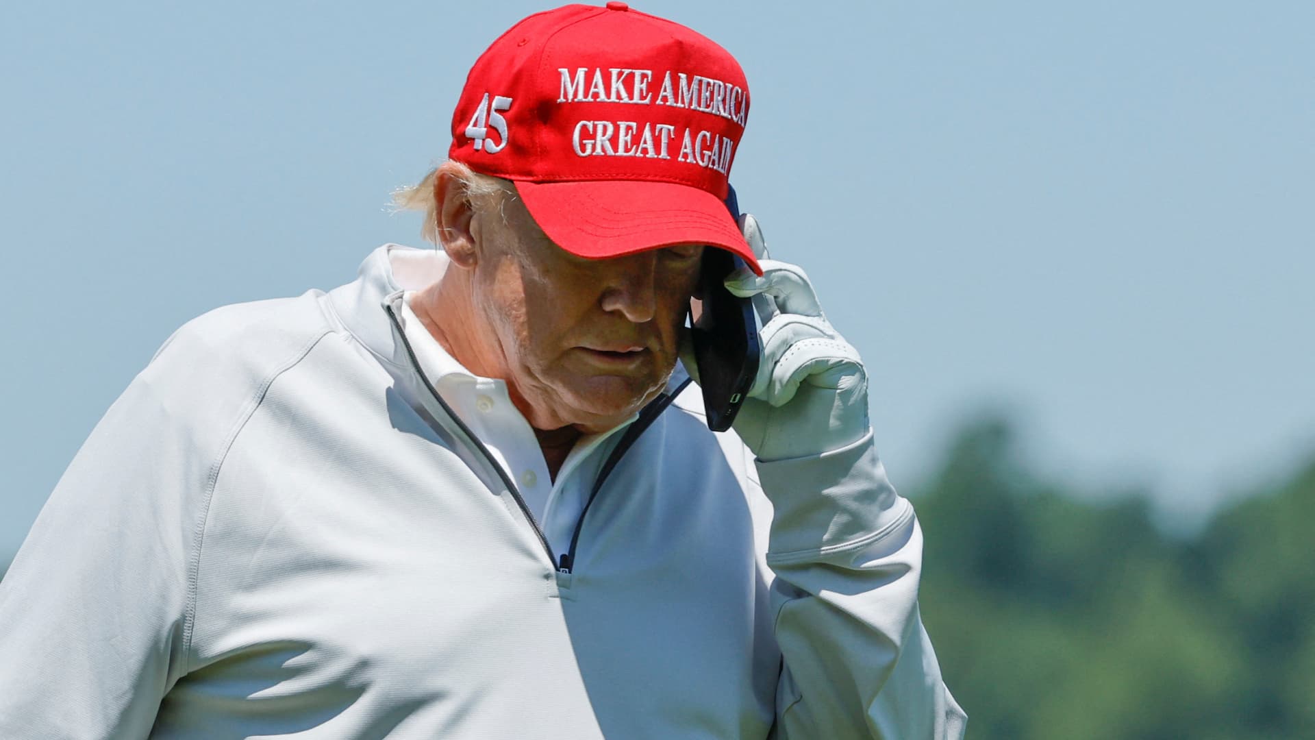 Former U.S. President Donald Trump talks on his phone between shots, as he participates in the Pro-Am tournament ahead of the LIV Golf Invitational at the Trump National Golf Club in Sterling, Virginia, U.S. May 25, 2023. 