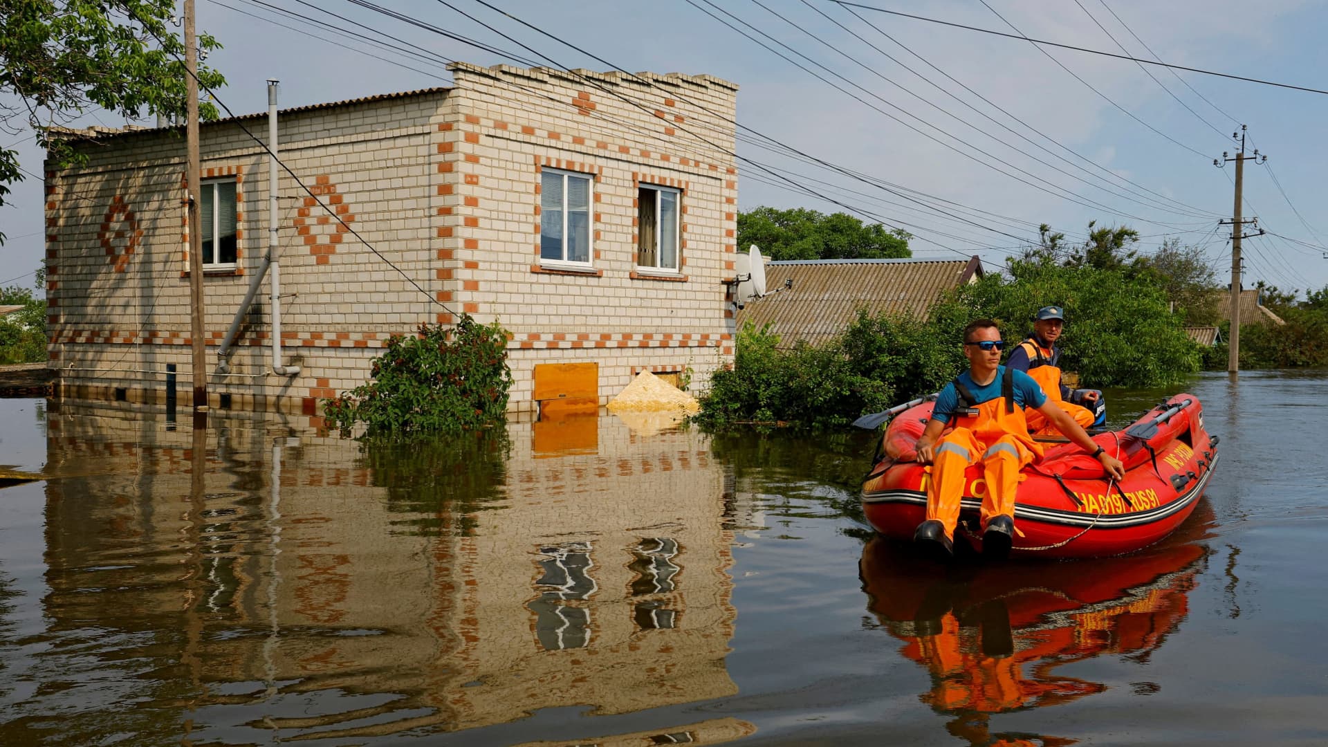 Members of Russia's emergencies ministry use an inflatable boat in a flooded area during a rescue operation following the collapse of the Nova Kakhovka dam in the course of Russia-Ukraine conflict, in the town of Hola Prystan in the Kherson region, Russian-controlled Ukraine, June 8, 2023. 